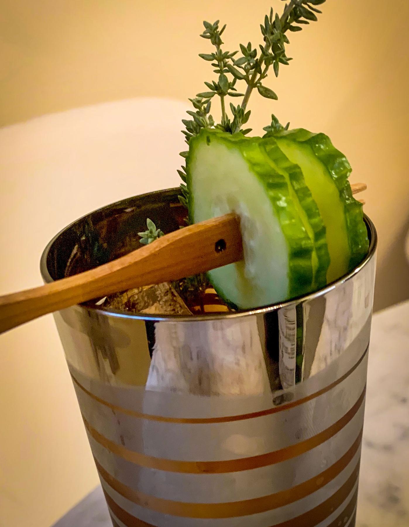 An example of the Little Dolomite, the mixed drink (drink), by Christina Helmer, NYC, featuring Pasubio Vino Amaro, Dolin Dry Vermouth de Chambéry, cucumber slice, and sprig of thyme