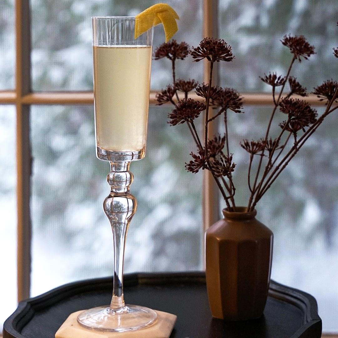 An example of the Austrian 75, the mixed drink (drink) featuring sparkling wine, Purkhart Pear Williams Eau-de-Vie, lemon juice, simple syrup, and lemon twist; photo by Madison Young