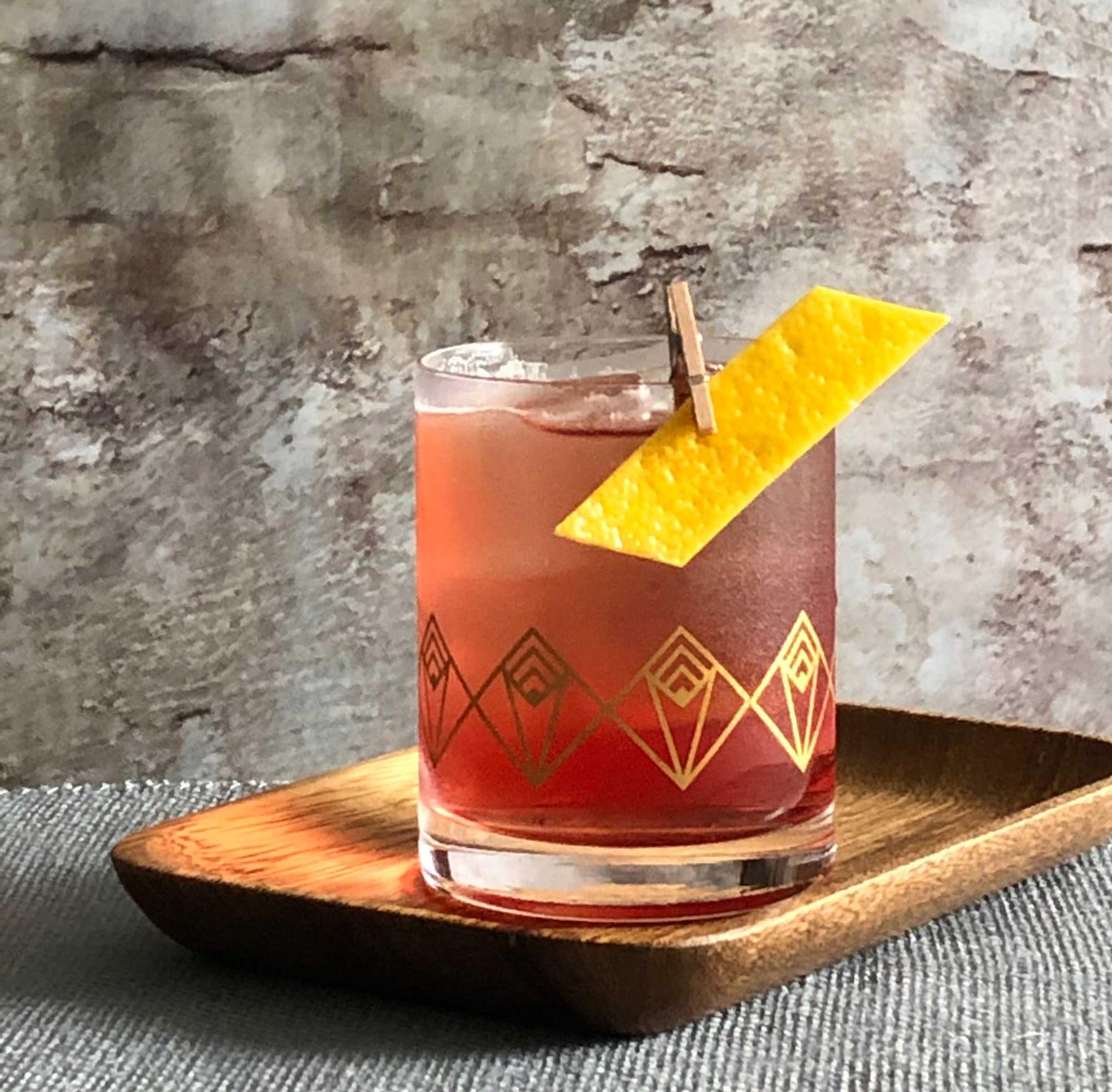 An example of the Refreshed Rosa, the mixed drink (drink) featuring Cocchi Americano Rosa, Dolin Blanc Vermouth de Chambéry, india pale ale, and lemon twist; photo by Lee Edwards