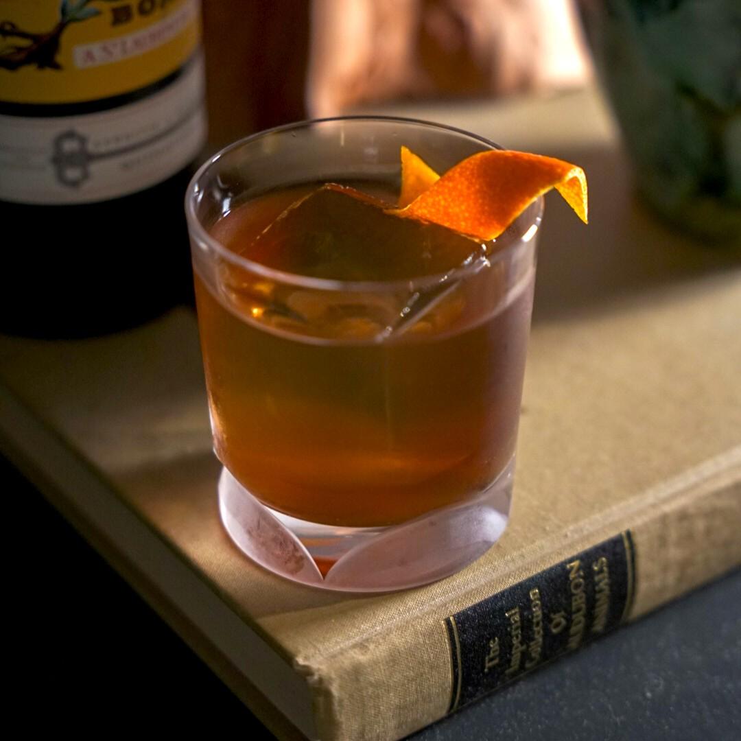 An example of the Fire on the Mountain, the mixed drink (drink) featuring Bonal Gentiane-Quina, single-malt scotch, orange bitters, and orange twist; photo by Madison Young