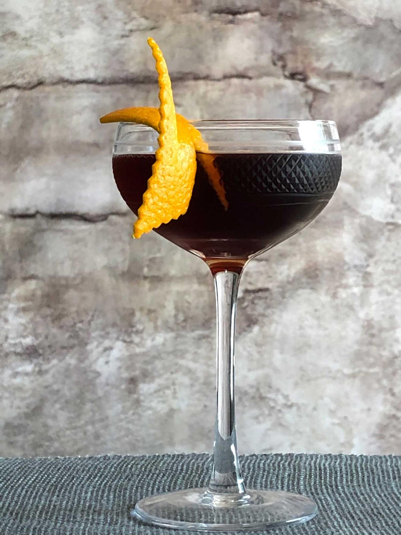 An example of the La Revuelta, the mixed drink (drink), by Lynn Falk, Acacia, Pittsburgh, featuring dark rum, Cocchi Dopo Teatro Vermouth Amaro, Amaro Sfumato Rabarbaro, Bittermens Xocolatl Mole Bitters, sprig of mint, and orange twist; photo by Lee Edwards