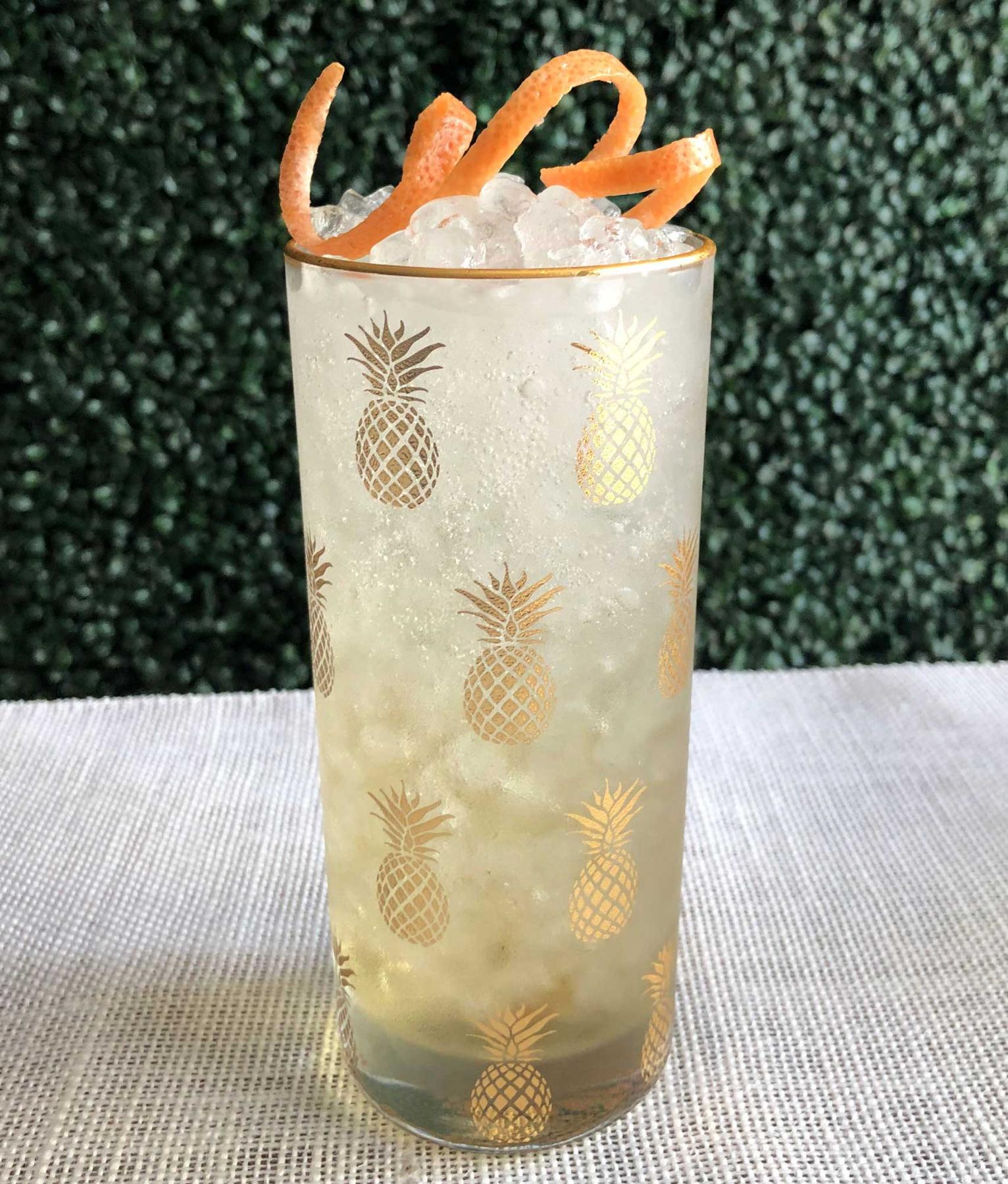 An example of the Proud and Prepared, the mixed drink (drink) featuring soda water, Comoz Blanc Vermouth de Chambèry, Mattei Cap Corse Blanc Quinquina, and grapefruit twist; photo by Lee Edwards