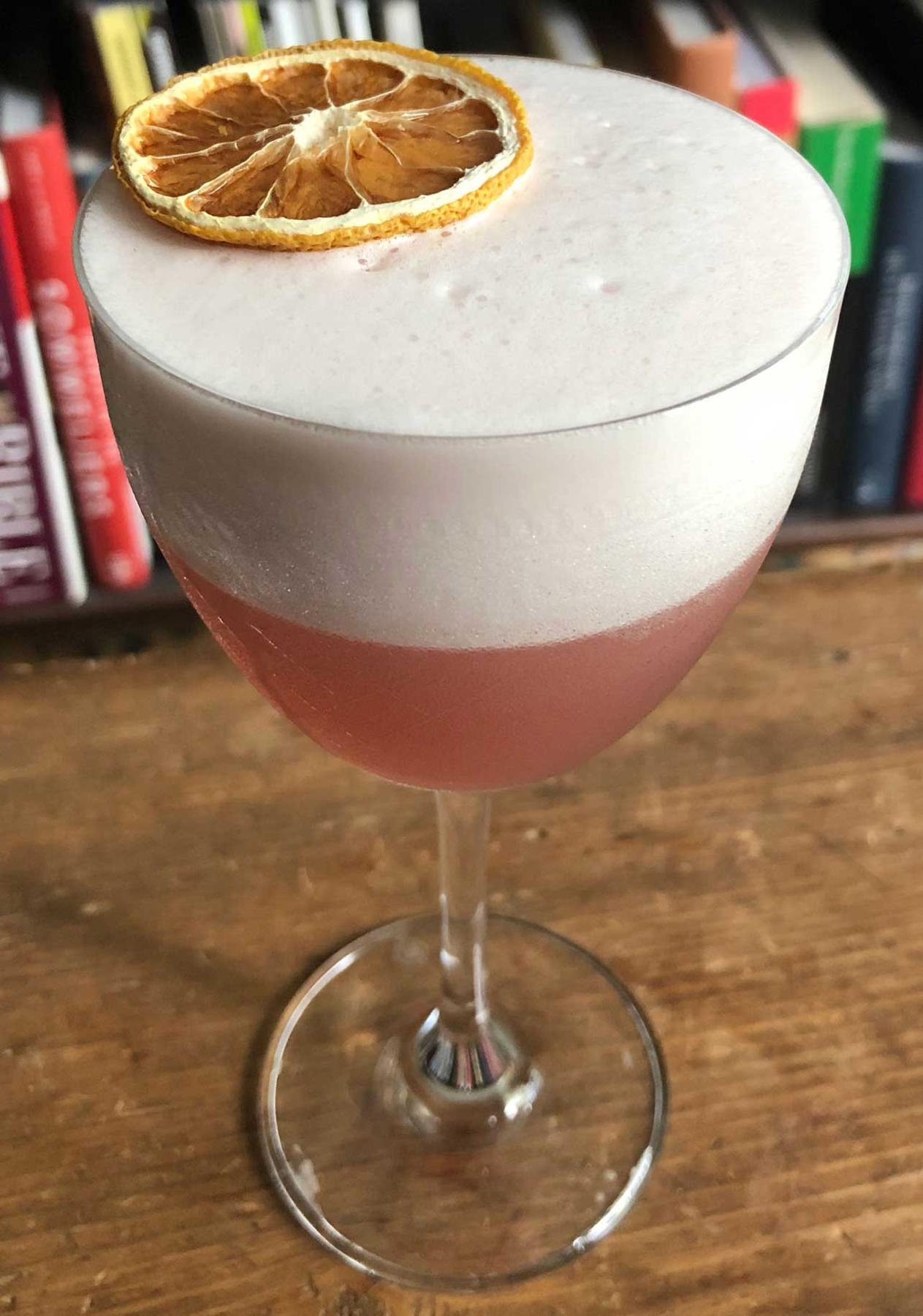 An example of the Rosa Sour, the mixed drink (drink) featuring Cocchi Americano Rosa, egg white, lemon juice, simple syrup, and lemon twist; photo by Lee Edwards