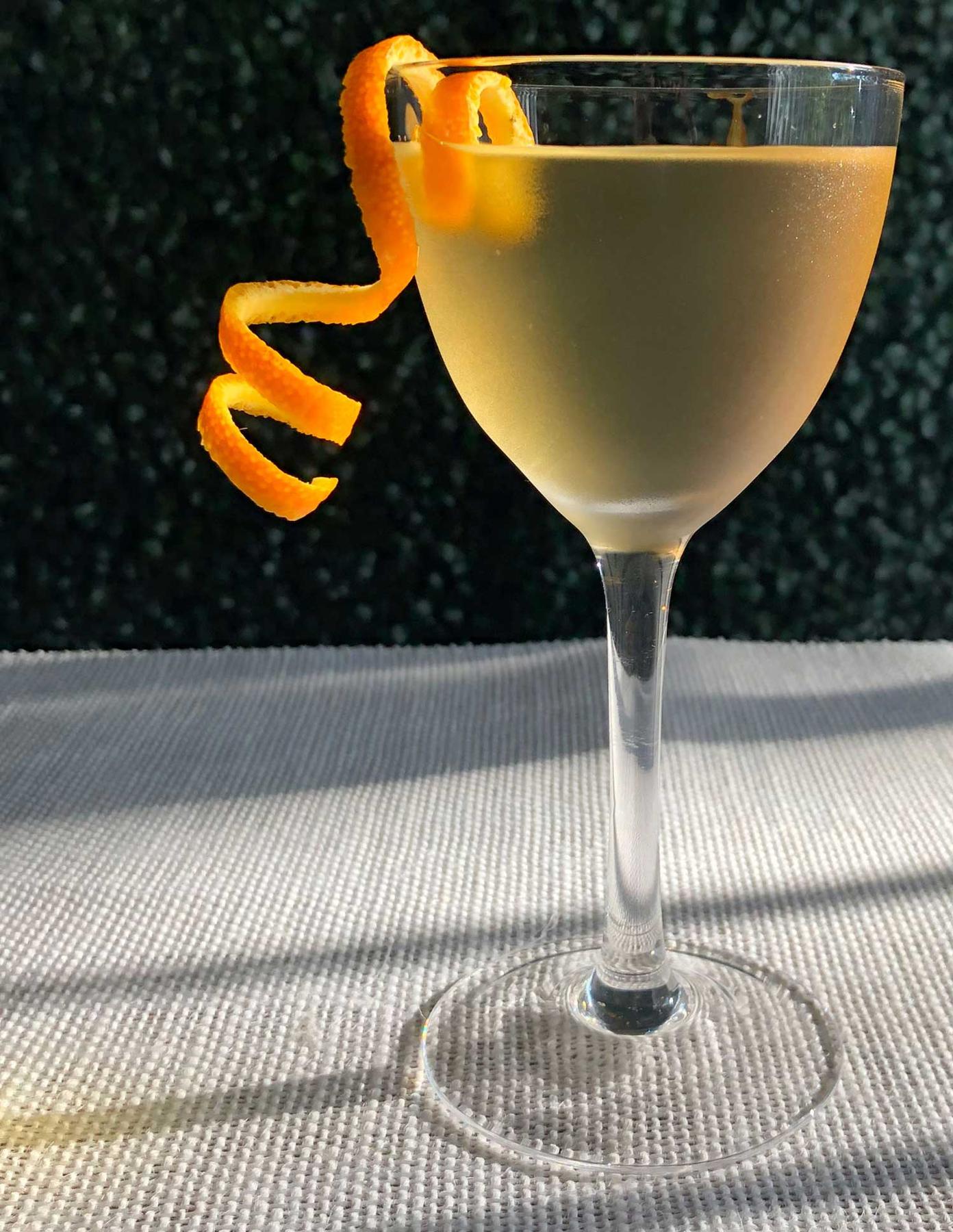 An example of the The Stirrup, the mixed drink (drink) featuring blanco tequila, Comoz Blanc Vermouth de Chambèry, KRONAN Swedish Punsch, and orange twist; photo by Lee Edwards