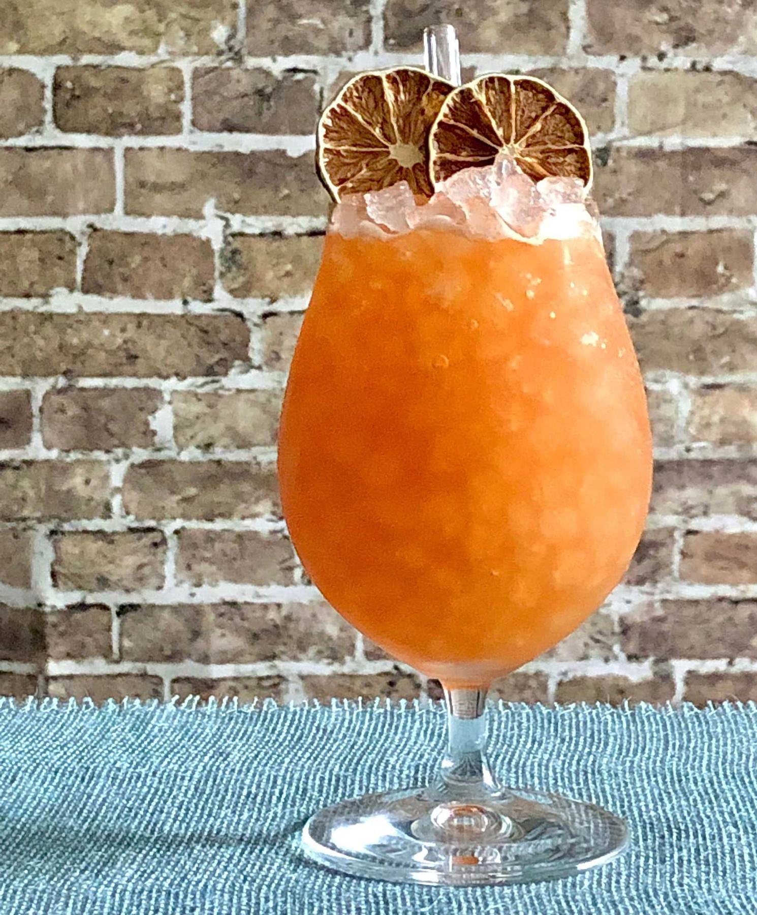 An example of the Anna Skytte’s Raid, the mixed drink (drink), by Luiggi Uzcategui, Big Orange, Little Rock, AR, featuring KRONAN Swedish Punsch, rye whiskey, lime juice, Smith & Cross Traditional Jamaica Rum, Carlsbad Becherovka Bitter, Angostura bitters, St. Elizabeth Allspice Dram, and lime wheel; photo by Lee Edwards
