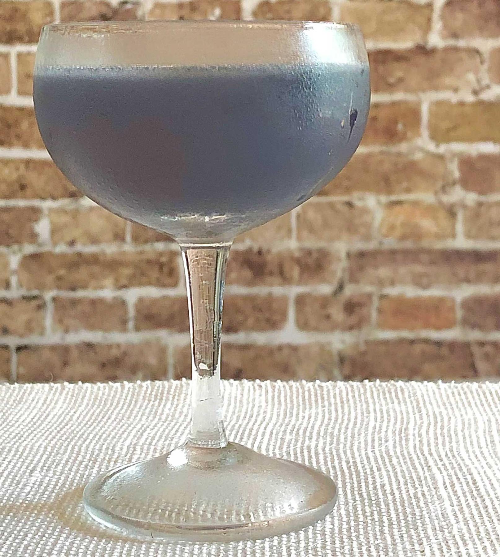 An example of the Blooey Blues, the mixed drink (drink), adapted from a drink from “Pioneers of Mixing at Elite Bars”, featuring light rum, Rothman & Winter Crème de Violette, lime juice, and Mas Peyre Rancio Sec “Le Démon de Midi”; photo by Lee Edwards
