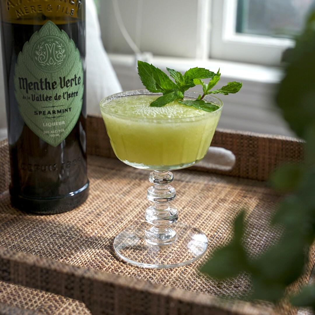 An example of the Honeydew List, the mixed drink (drink) featuring The Scarlet Ibis Trinidad Rum, Menthe Verte Spearmint Liqueur, lime juice, orgeat, honeydew melon, and crushed ice; photo by Madison Young
