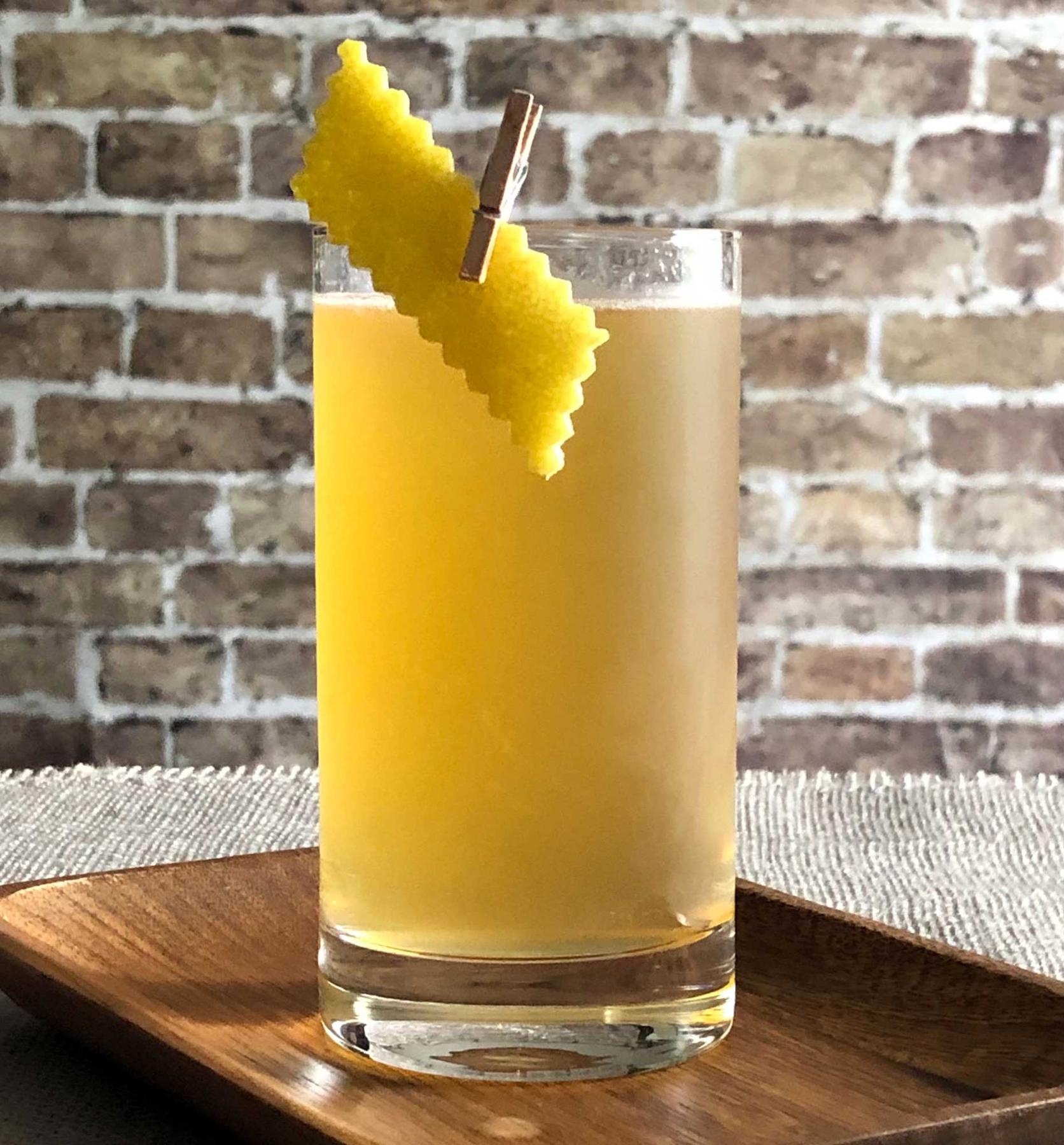 An example of the Apricot Beer Collins, the mixed drink (drink) featuring white beer, Hayman’s Old Tom Gin, Rothman & Winter Orchard Apricot Liqueur, lemon juice, and lemon twist; photo by Lee Edwards