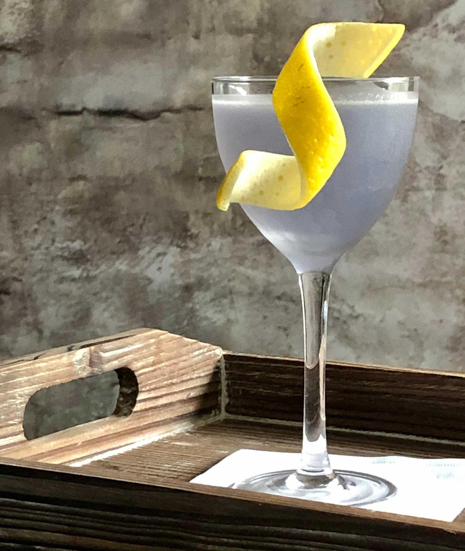 An example of the Blue Moon, the mixed drink (drink) featuring Hayman’s London Dry Gin, Rothman & Winter Crème de Violette, lemon juice, and lemon twist; photo by Lee Edwards