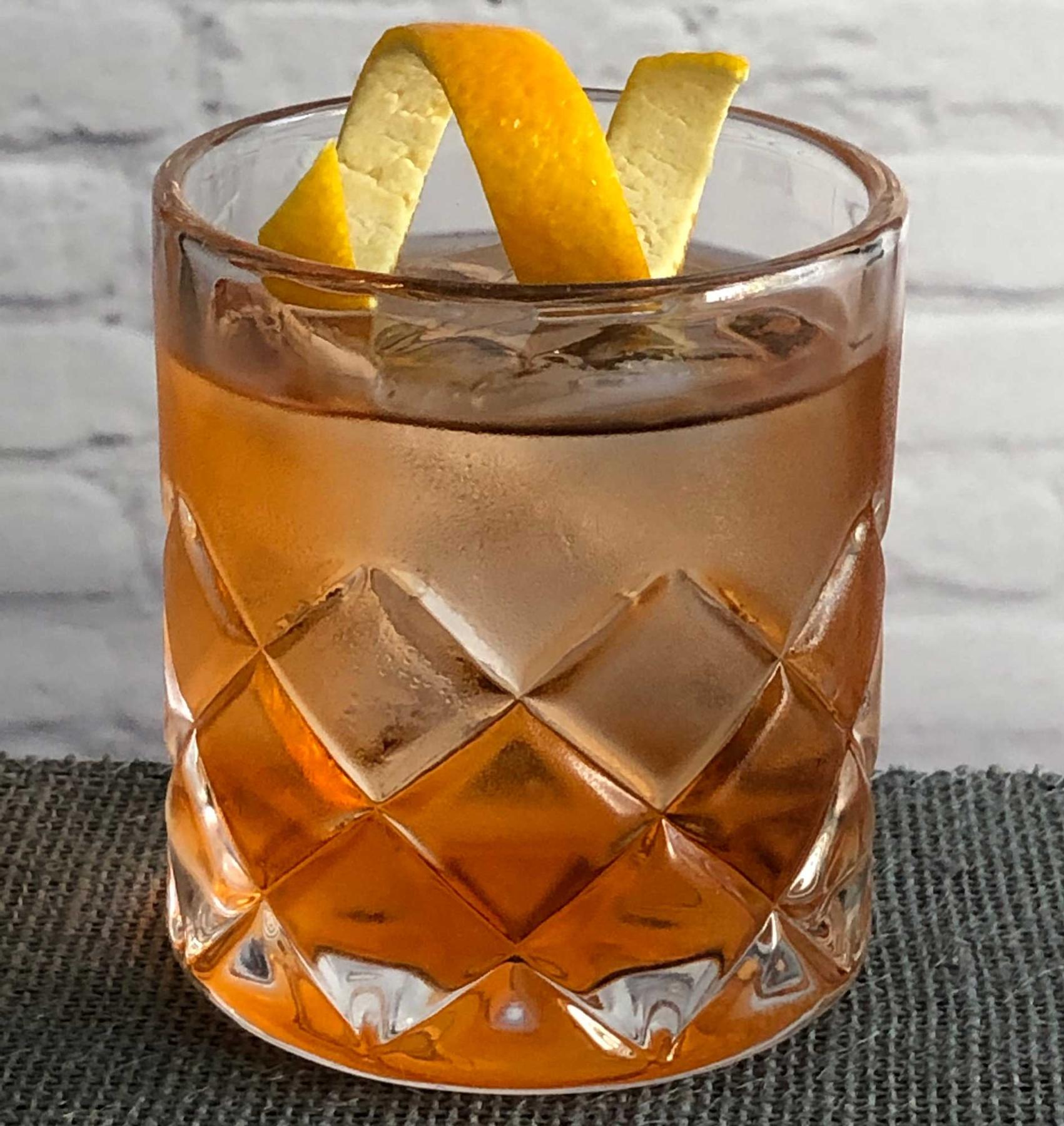 An example of the Rosita, the mixed drink (drink) featuring blanco tequila, Dolin Dry Vermouth de Chambéry, Dolin Rouge Vermouth de Chambéry, Aperitivo Cappelletti, and orange twist; photo by Lee Edwards