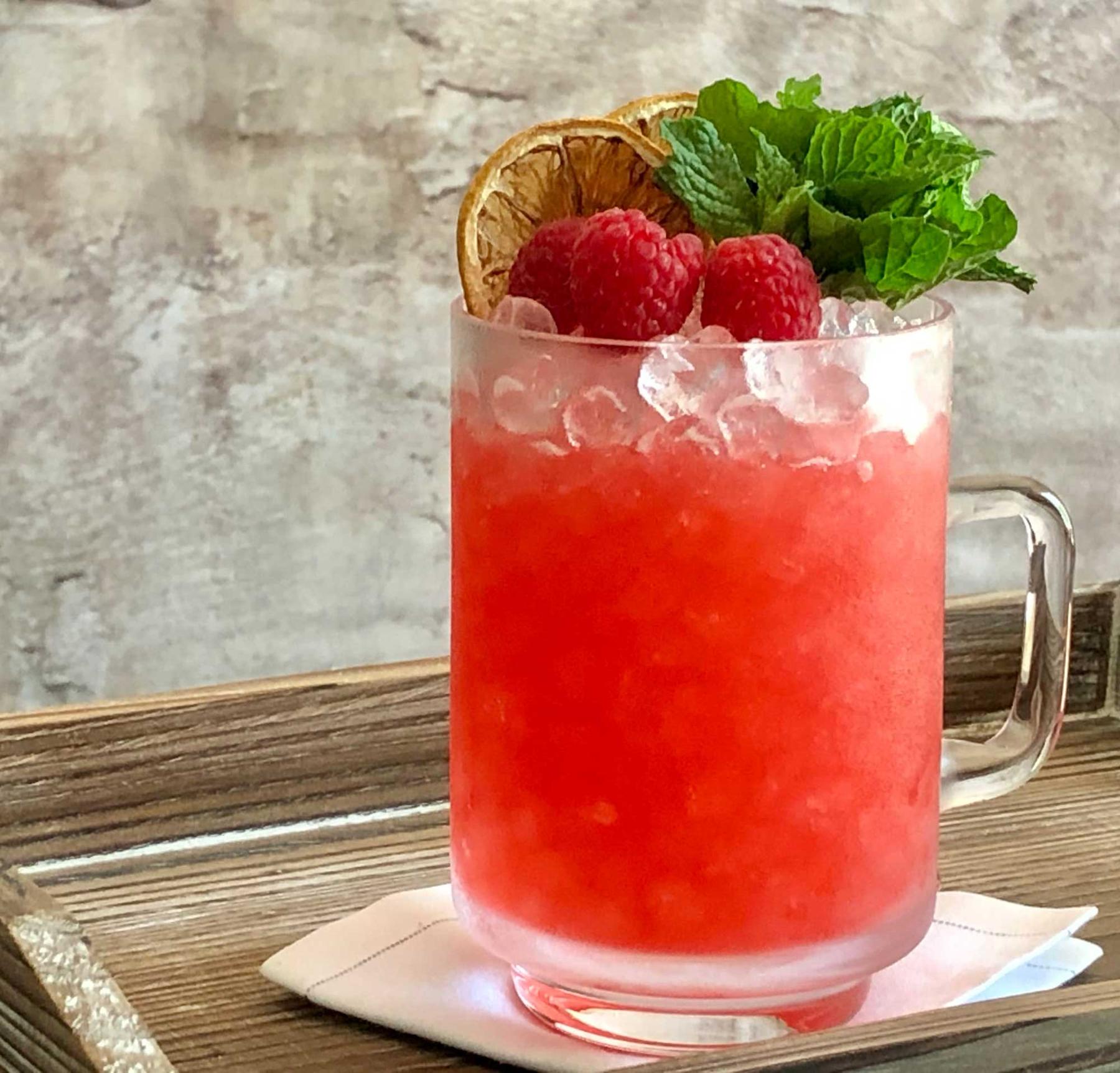 An example of the Salers Cobbler, the mixed drink (drink), by Sal Agnello, New Orleans, LA, featuring Salers Gentian Apéritif, raspberries, lemon wheel, sugar, raspberries, mint, and lemon wheel; photo by Lee Edwards