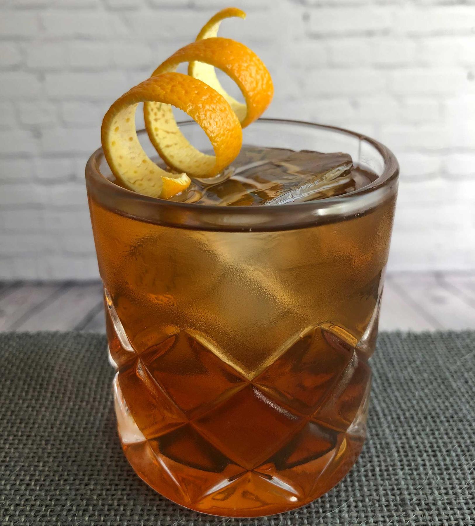 An example of the Sentier en Bastia, the mixed drink (drink) featuring rye whiskey, Mattei Cap Corse Rouge Quinquina, Dolin Rouge Vermouth de Chambéry, and orange twist; photo by Lee Edwards
