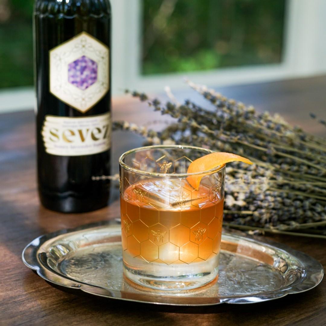An example of the Lavender Old Fashioned, the mixed drink (drink) featuring bourbon whiskey, Sevez Honey Lavender, syrup, Angostura bitters, and orange twist; photo by Madison Young