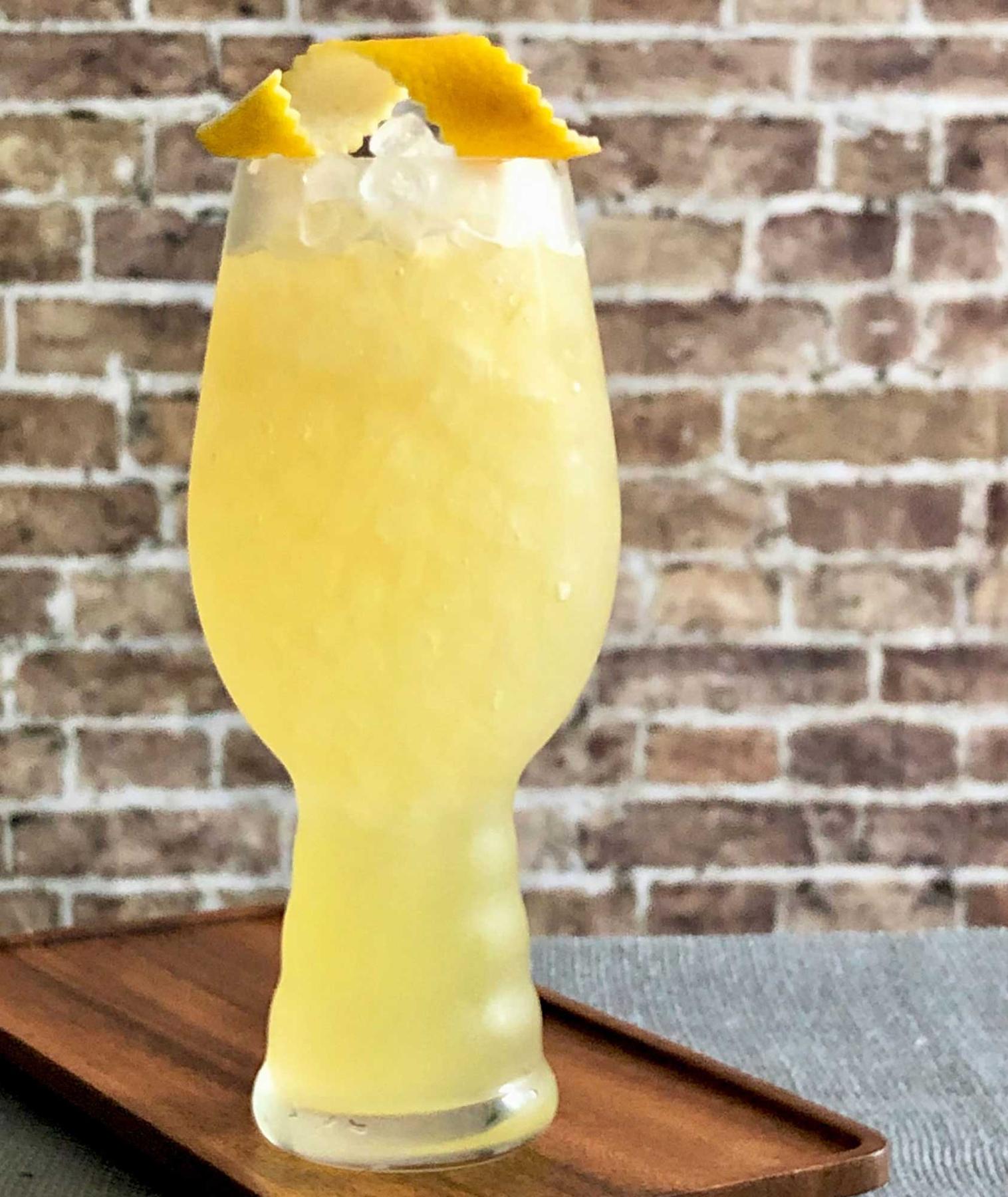 An example of the Strange Brew, the mixed drink (drink), adapted from a drink from Death & Co., New York City, featuring india pale ale, Hayman’s London Dry Gin, pineapple juice, John D. Taylor’s Velvet Falernum, lemon juice, and lemon twist; photo by Lee Edwards