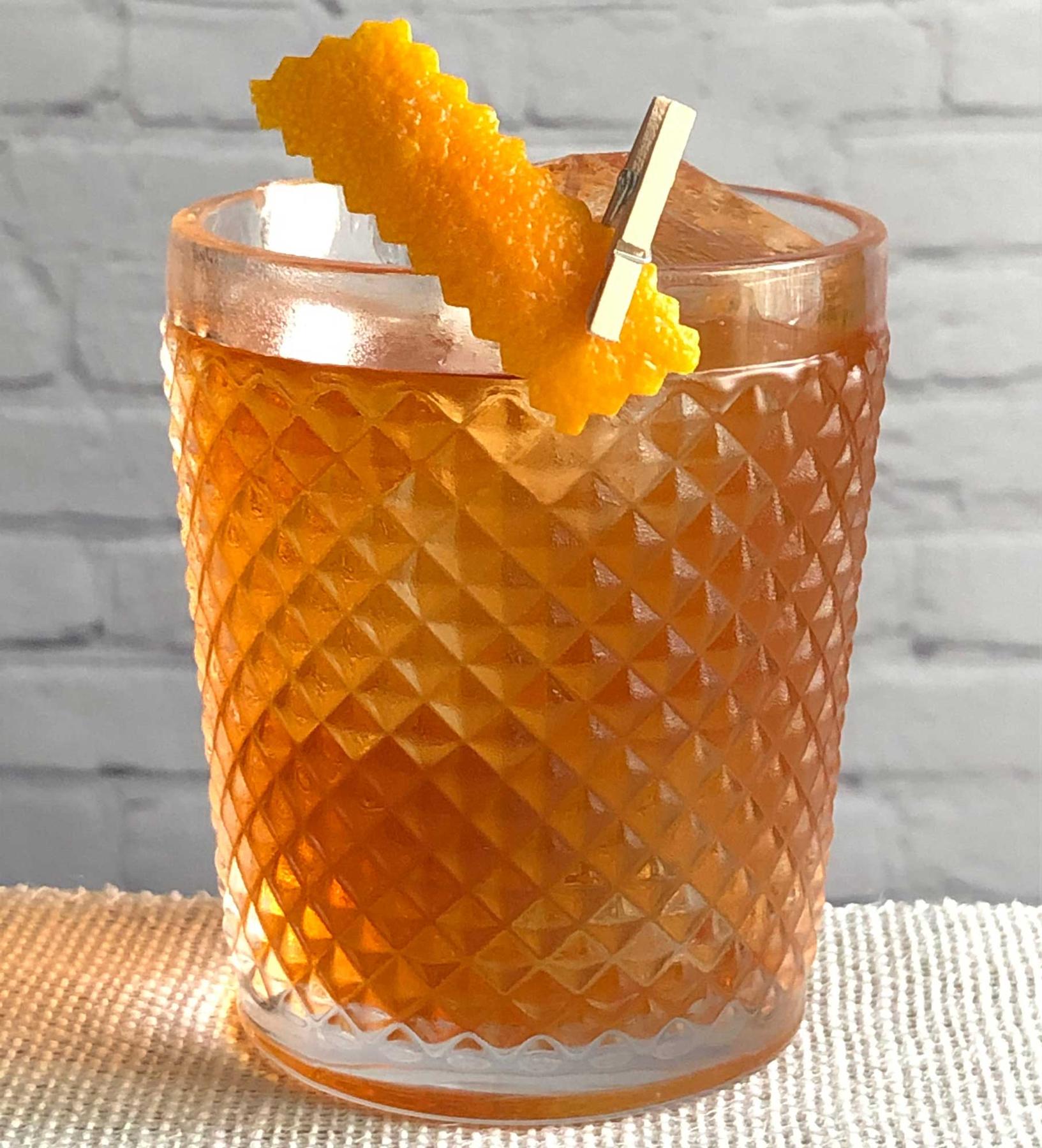 An example of the Double Dagger, the mixed drink (drink), by Jason Harris, featuring Hayman’s Royal Dock Navy Strength Gin, Cardamaro Vino Amaro, Aperitivo Cappelletti, Dolin Blanc Vermouth de Chambéry, orange bitters, and orange twist; photo by Lee Edwards