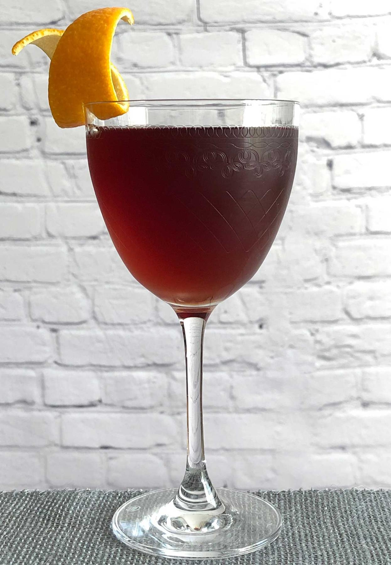 An example of the Dessert Manhattan, the mixed drink (drink) featuring bourbon whiskey, Cocchi Dopo Teatro Vermouth Amaro, and orange twist; photo by Lee Edwards