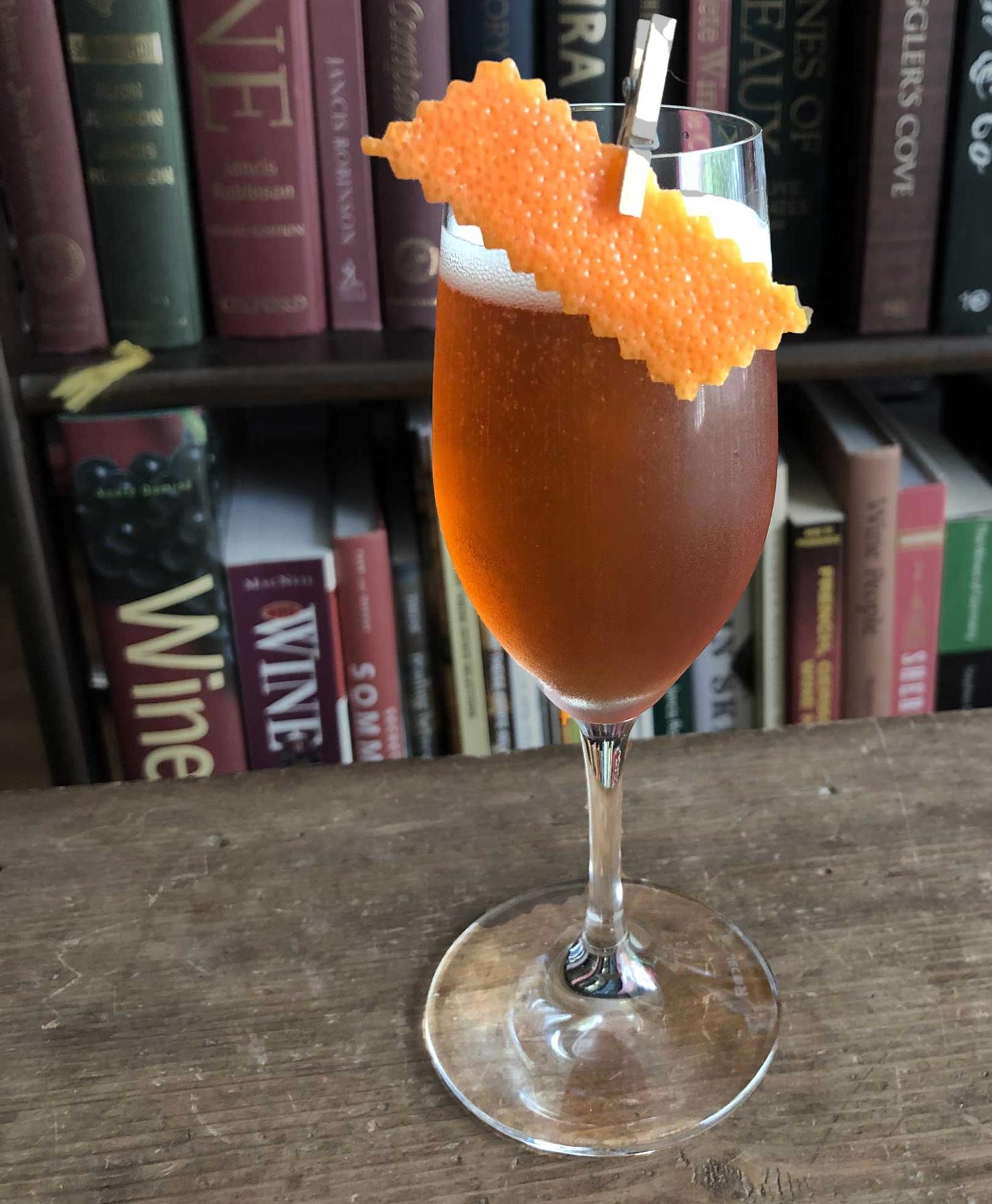 An example of the Gregorian Chant, the mixed drink (drink) featuring sparkling wine, Hayman’s Sloe Gin, Amaro Alta Verde, Bénédictine, sparkling wine, and grapefruit twist; photo by Lee Edwards