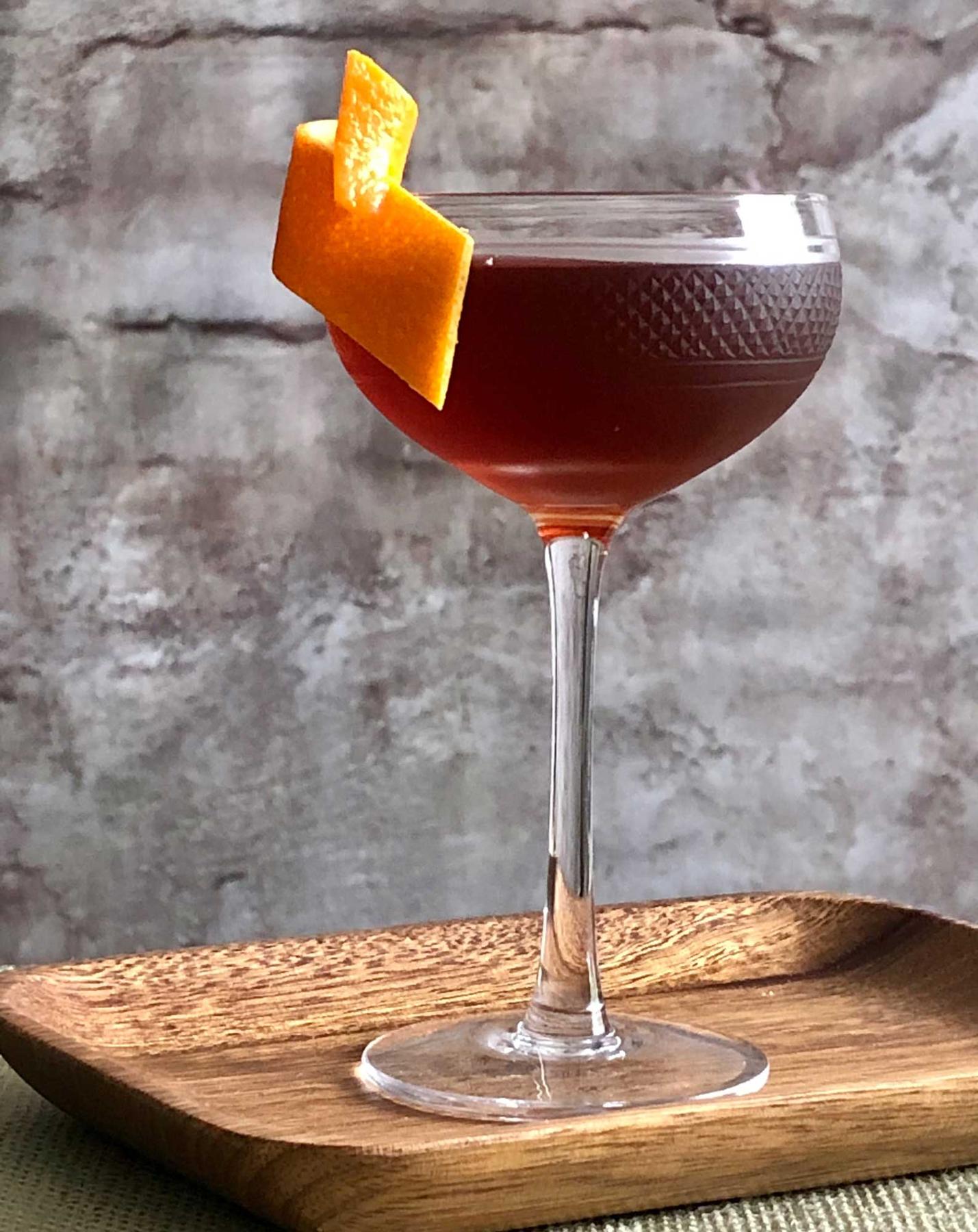 An example of the Stadium of Light, the mixed drink (drink) featuring Henriques & Henriques Rainwater Madeira, Dolin Rouge Vermouth de Chambéry, orange bitters, Angostura bitters, and orange twist; photo by Lee Edwards