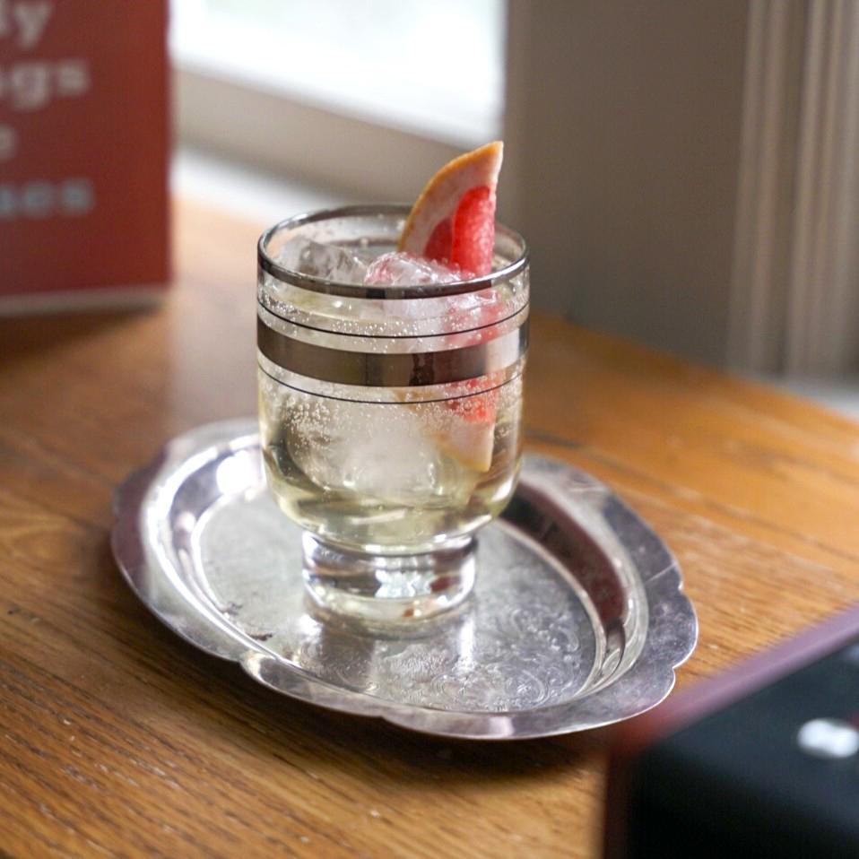 An example of the Bitter Spritz, the mixed drink (drink), by Dean McHong, Cincinnati, featuring sparkling wine, Cocchi Americano Bianco, Comoz Blanc Vermouth de Chambèry, soda water, Amaro Alta Verde, and grapefruit wedge; photo by Madison Young