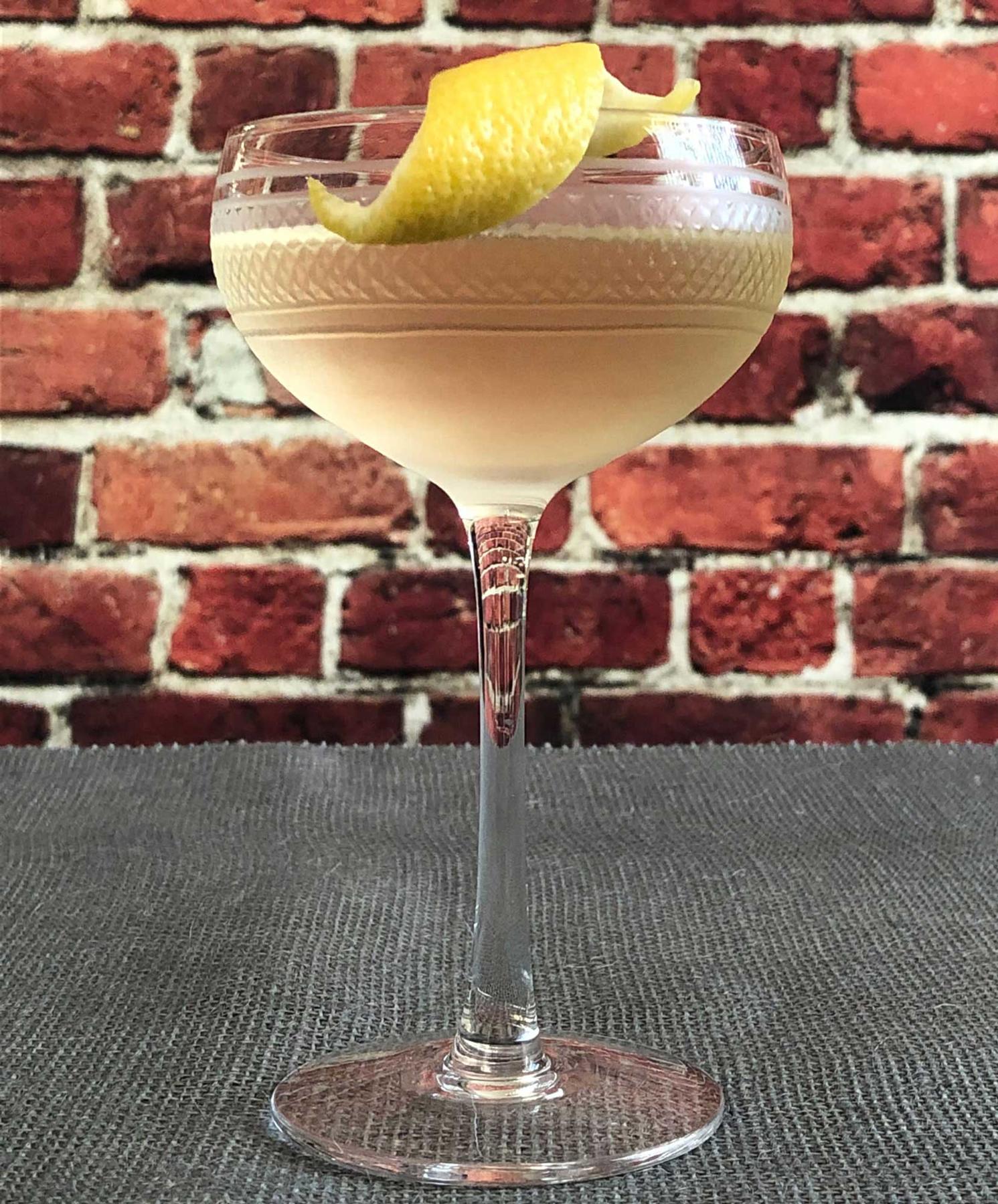 An example of the Eddie Brown, the mixed drink (drink), adapted from the Savoy Cocktail Book, featuring Hayman’s Old Tom Gin, Cocchi Americano Bianco, Blume Marillen Apricot Eau-de-Vie, simple syrup, and lemon twist; photo by Lee Edwards