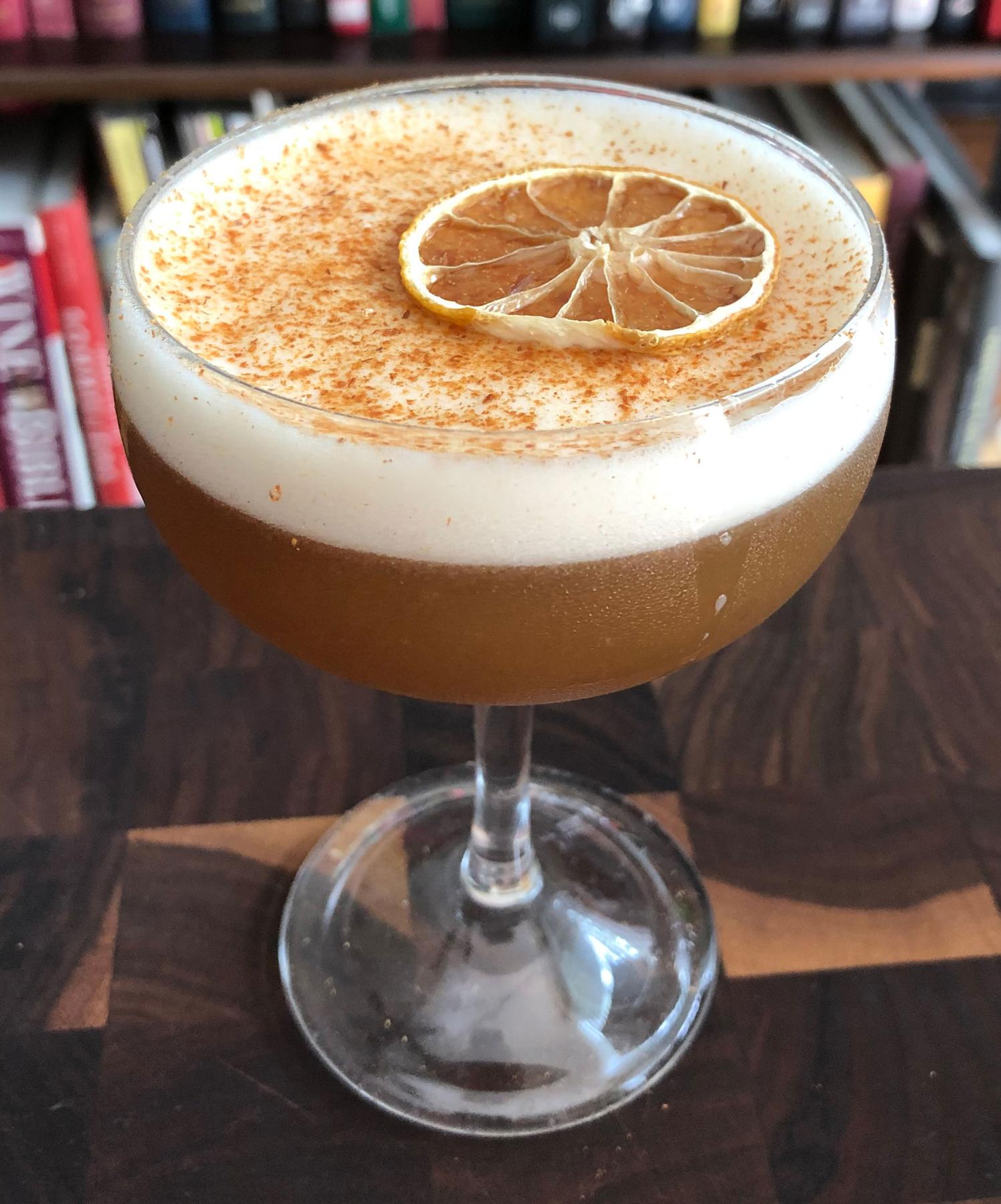 An example of the Golden Brown, the mixed drink (drink), by Angelica Tea Room, Buffalo NY, featuring Bonal Gentiane-Quina, rye whiskey, lemon juice, egg white, cinnamon-infused sugar syrup, Angostura bitters, lemon twist, and cinnamon; photo by Lee Edwards