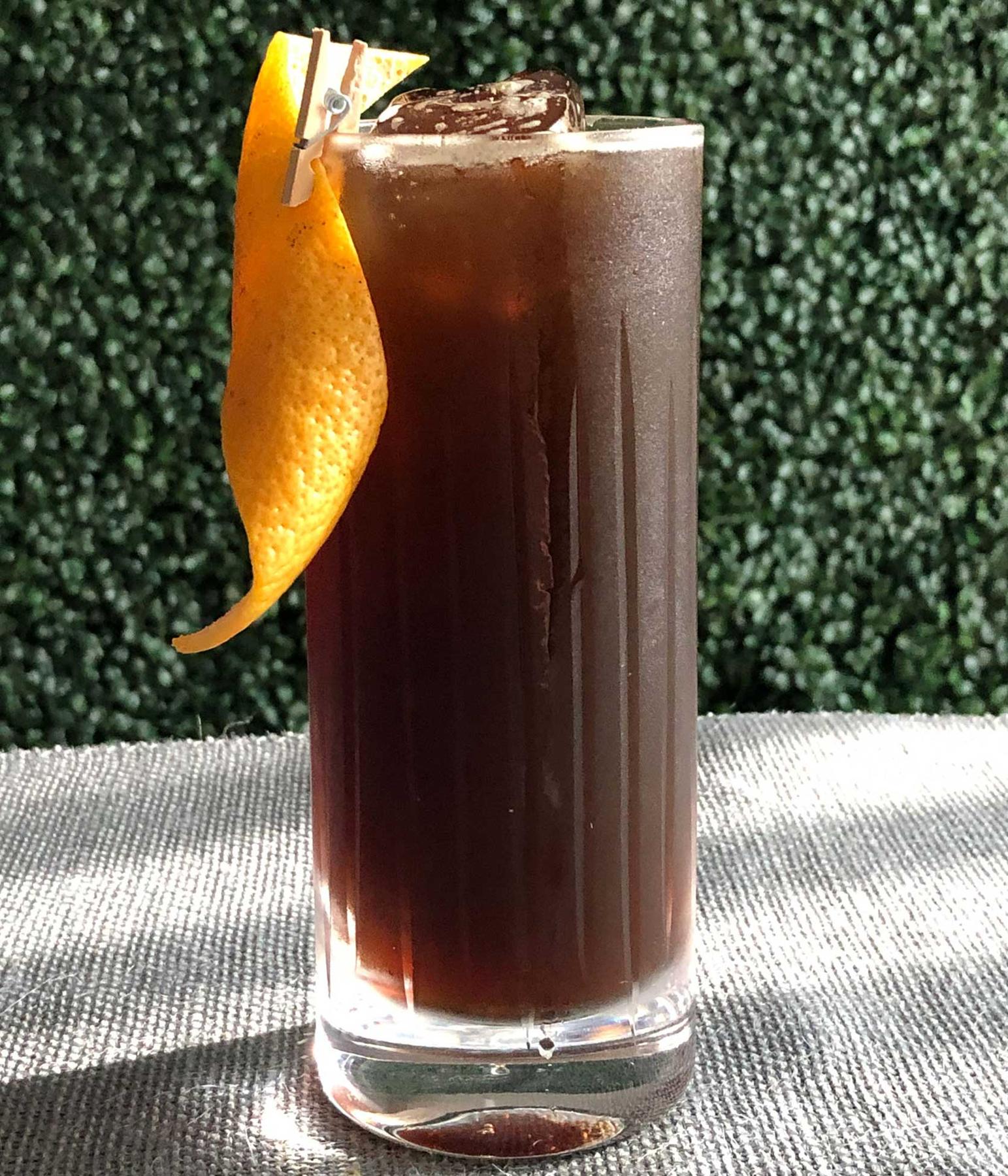An example of the Poker Face, the mixed drink (drink) featuring Fentimans Curiosity Cola, Elisir Novasalus, Salers Gentian Apéritif, Zirbenz Stone Pine Liqueur of the Alps, and grapefruit twist; photo by Lee Edwards