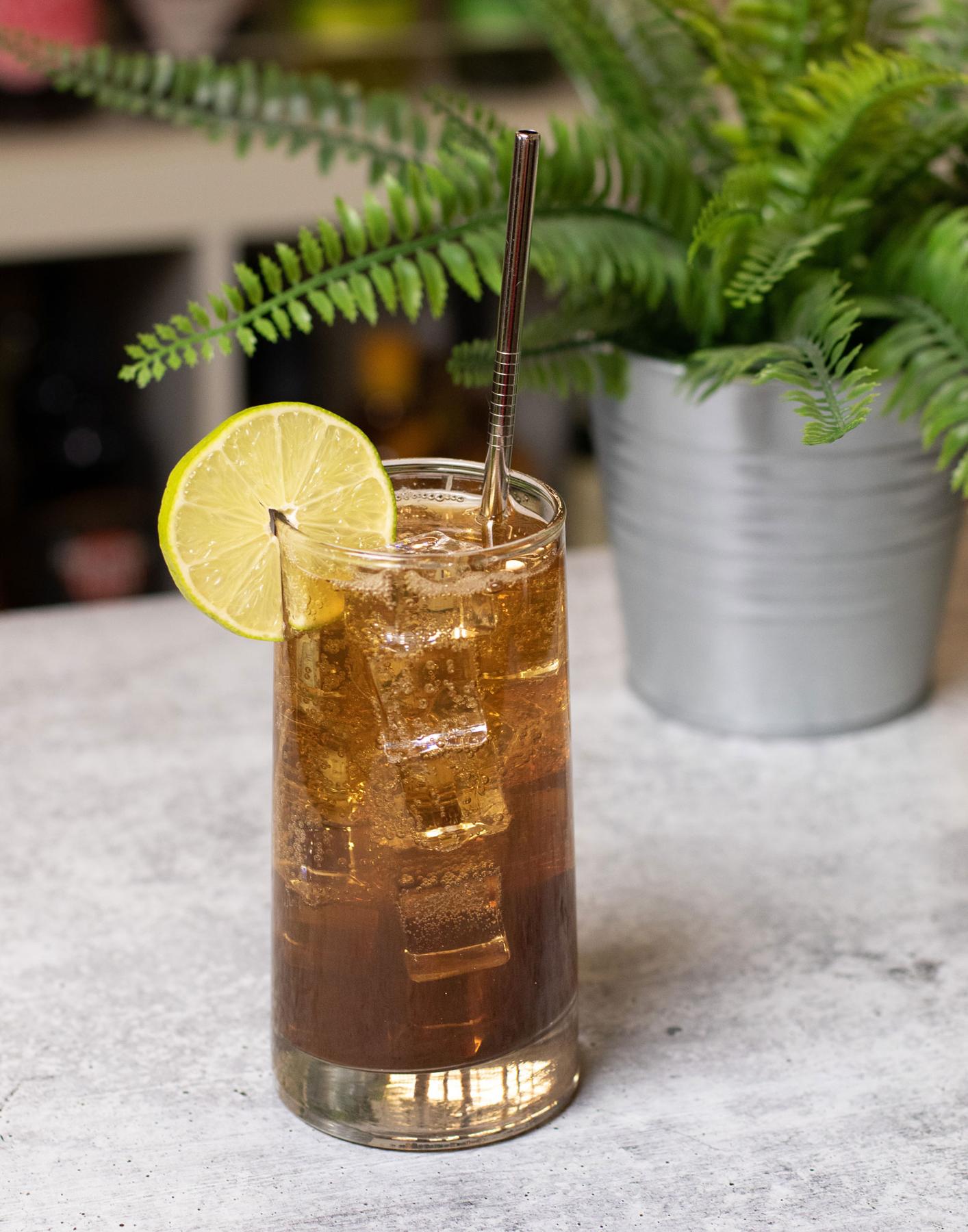 An example of the Espresso Tonic Royale, the mixed drink (drink) featuring tonic water, cold brew coffee, lime juice, Etter Kirsch, and lime wedge; photo by Boon and Caro Sheridan