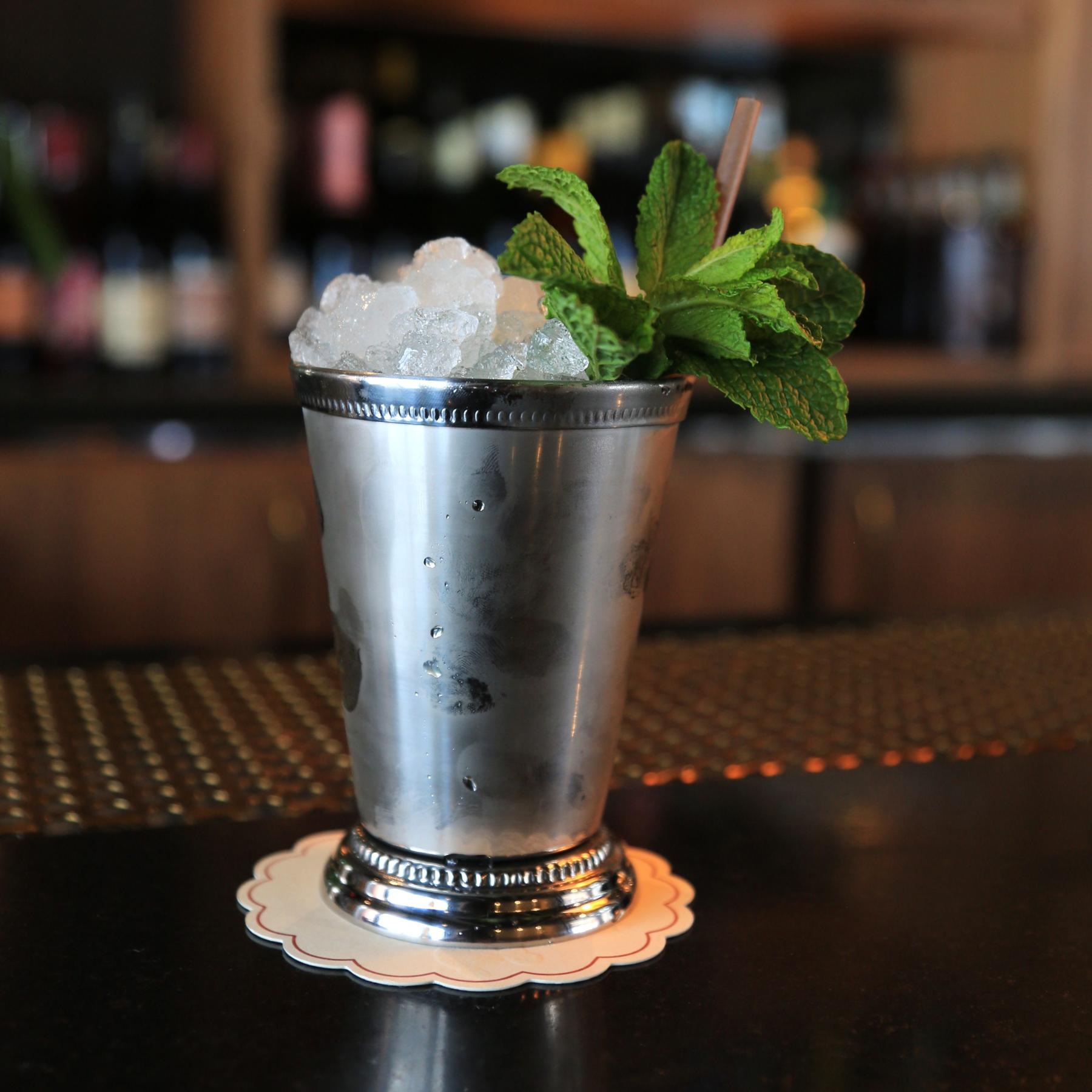 An example of the Mint Julep, the mixed drink (drink) featuring bourbon whiskey, Menthe Verte de la Vallée de l’Isère, Angostura bitters, and mint leaf; photo by Megan Heinowski