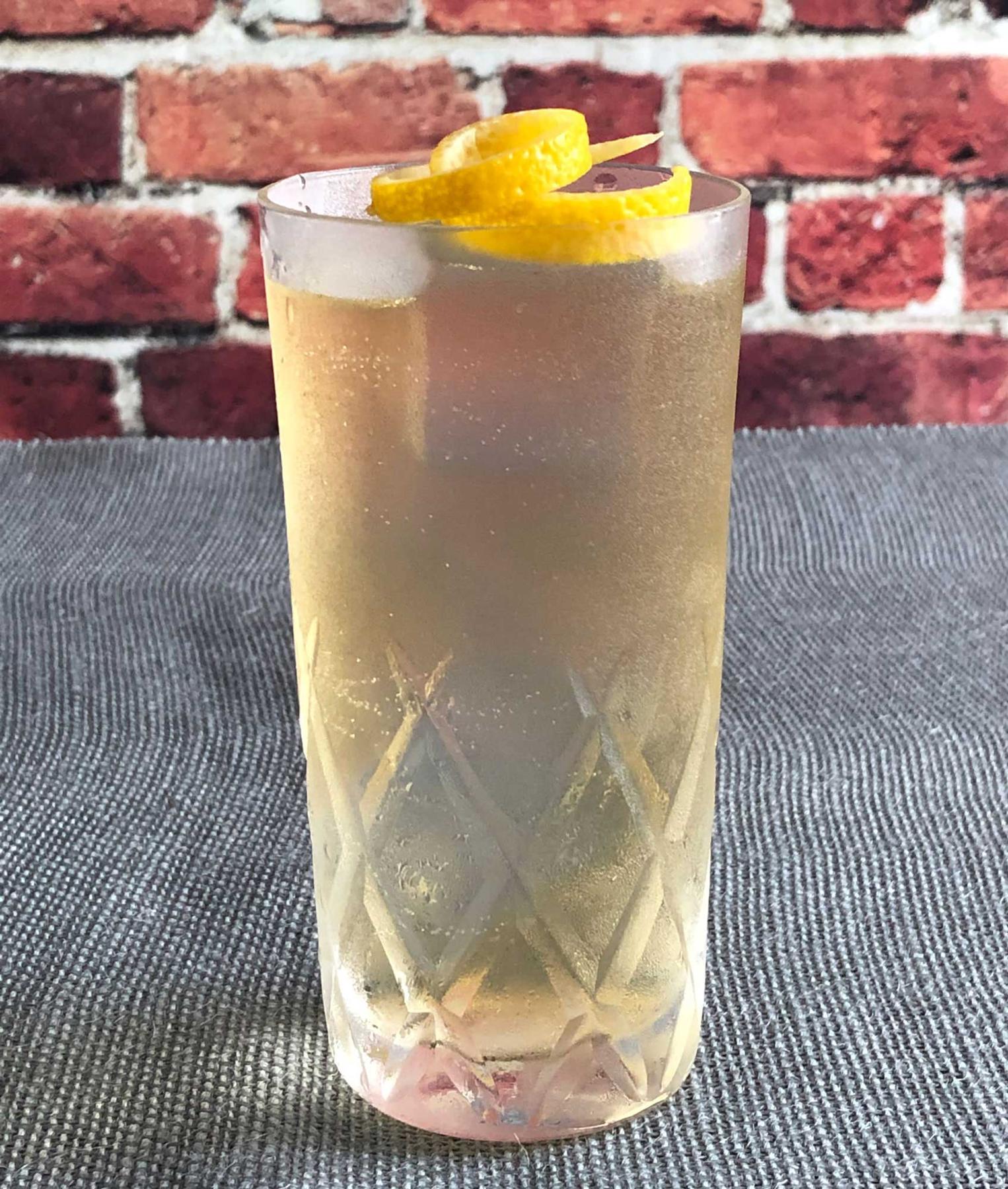 An example of the Auvergne Summer, the mixed drink (drink) featuring Rothman & Winter Orchard Peach Liqueur, Salers Gentian Apéritif, soda water, lemon wedge, and grapefruit twist; photo by Lee Edwards