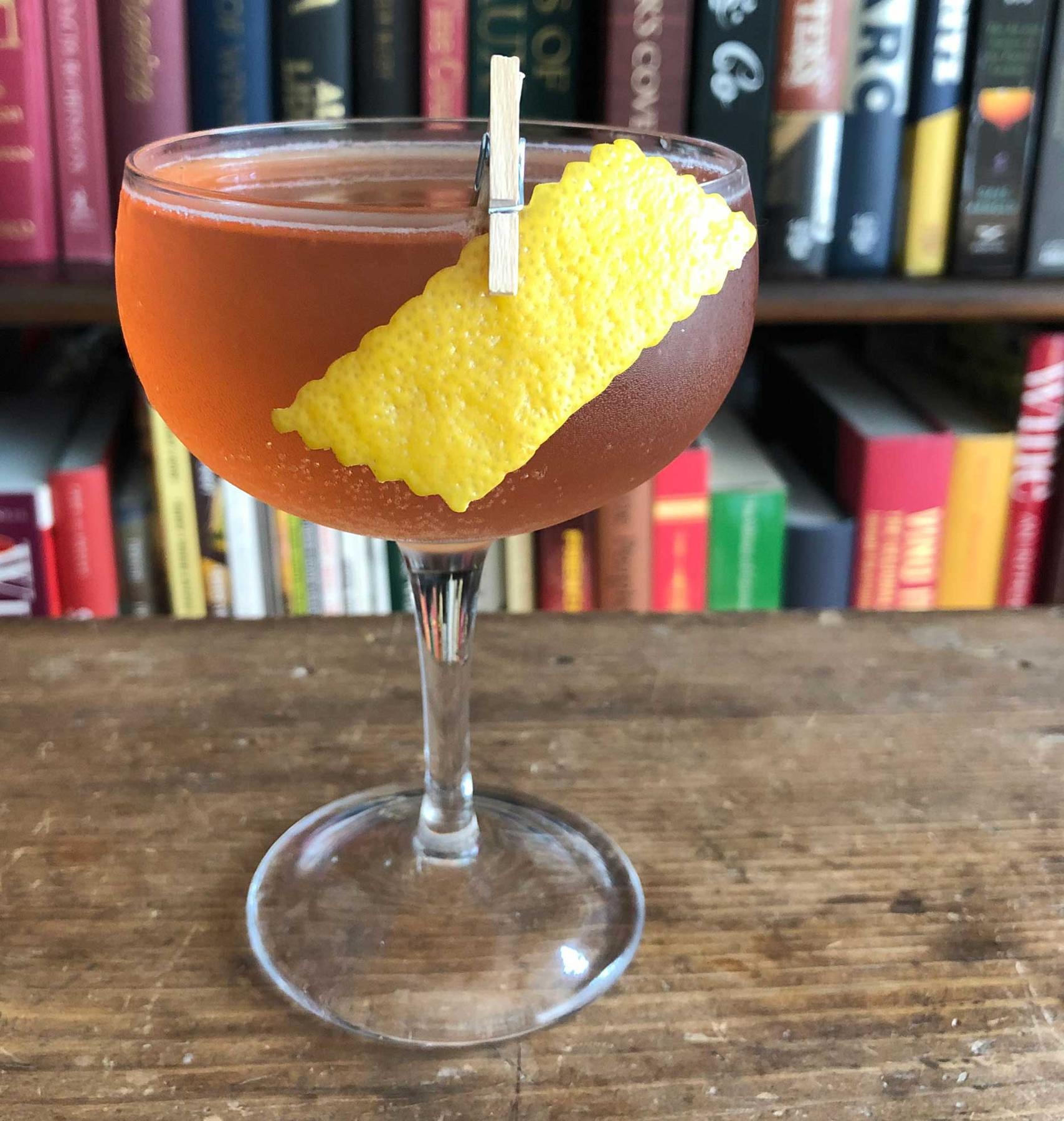 An example of the Stone Cooler, the mixed drink (drink) featuring sparkling wine, Averell Damson Plum Gin Liqueur, Blume Marillen Apricot Eau-de-Vie, Cocchi Americano Bianco, lemon juice, and lemon twist; photo by Lee Edwards