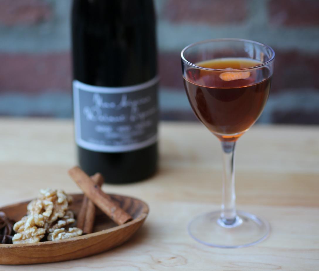 An example of the Black Manhattan, the mixed drink (drink) featuring rye whiskey, Cocchi Vermouth di Torino ‘Storico’, Nux Alpina Walnut Liqueur, and orange twist; photo by Lauren Clark