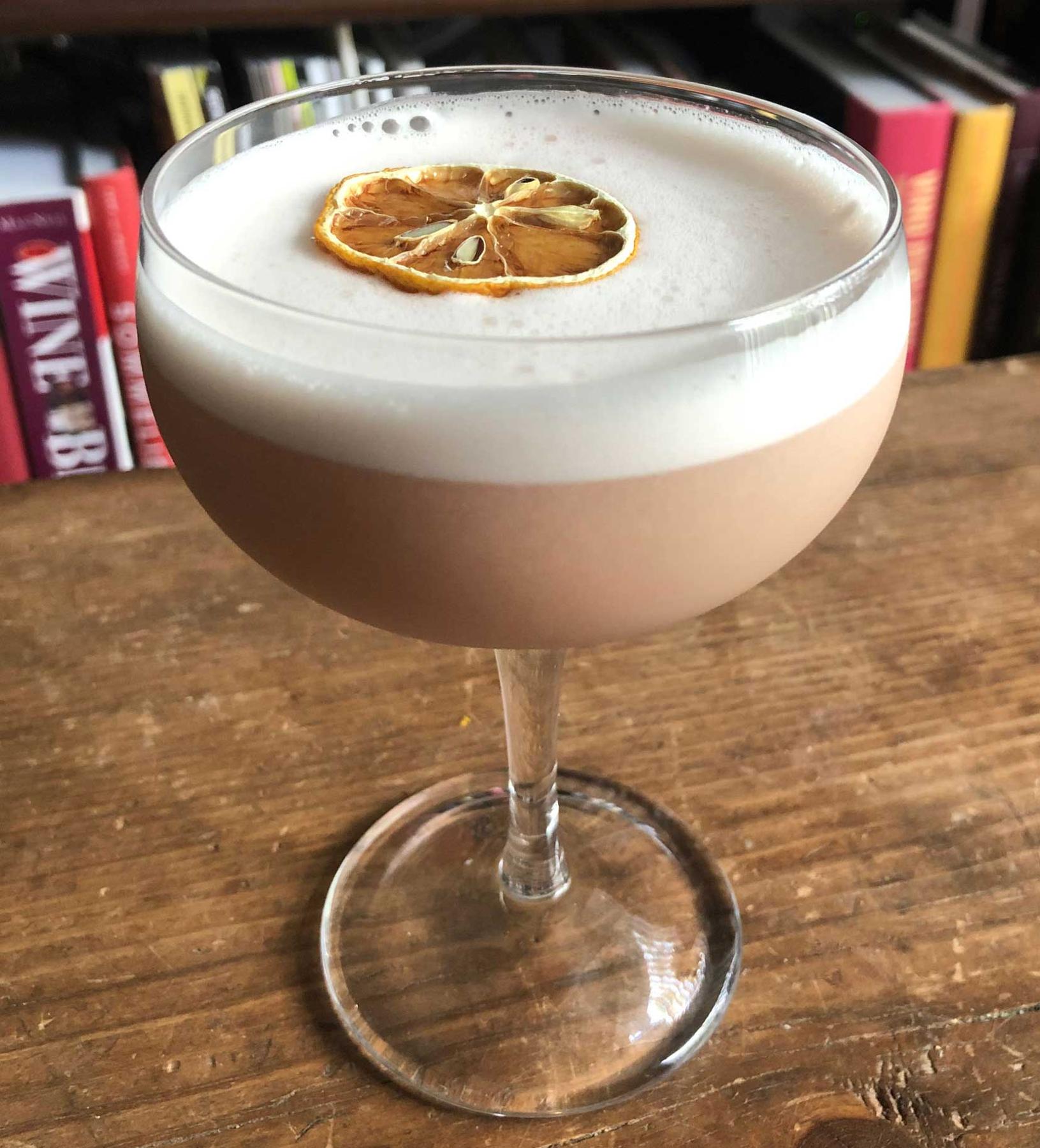 An example of the Ocean Shore, the mixed drink (drink), by Boothby, featuring Hayman’s Royal Dock Navy Strength Gin, Hayman’s Sloe Gin, egg white, orgeat, lemon juice, and lemon twist; photo by Lee Edwards