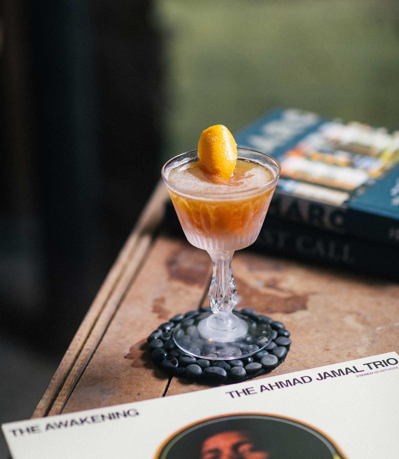 An example of the Lush Interlude, the mixed drink (drink), by Braden LaGrone, Cure, New Orleans, featuring Amaro Sfumato Rabarbaro, brown rum, lime juice, orange brandy, rich demerara syrup, and orange twist; photo by S. Kallstrand