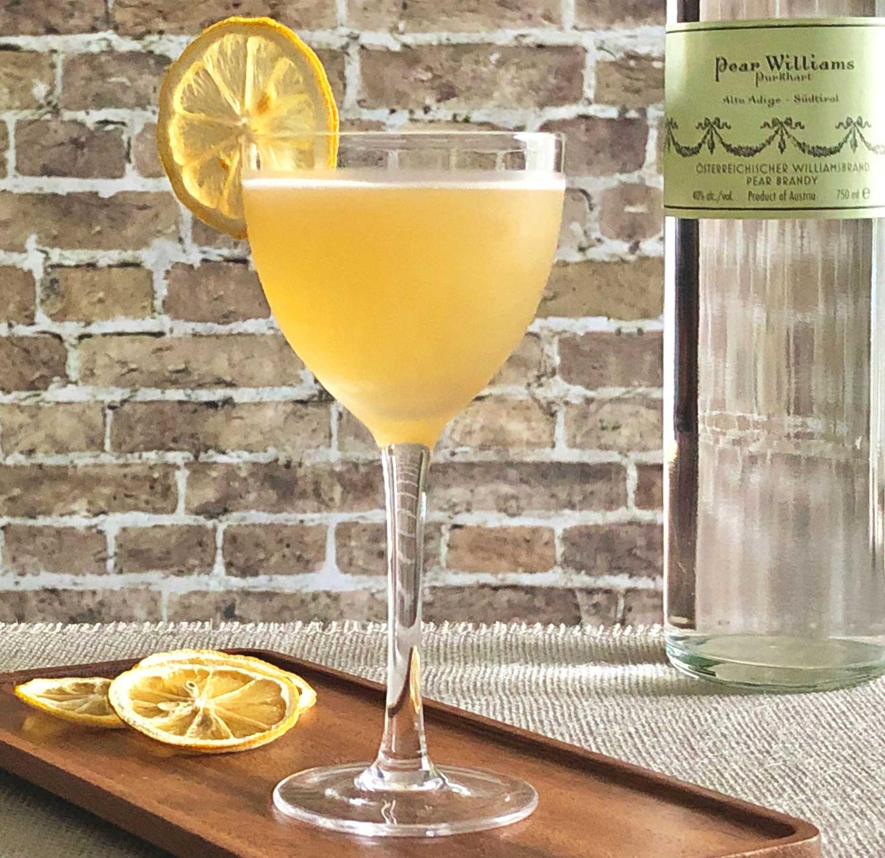 An example of the Good Christian Pear, the mixed drink (drink), by David Burnette, South on Main, Little Rock, Arkansas, featuring Purkhart Pear Williams Eau-de-Vie, honey syrup, lemon juice, pastis, pear, and lemon wheel; photo by Lee Edwards