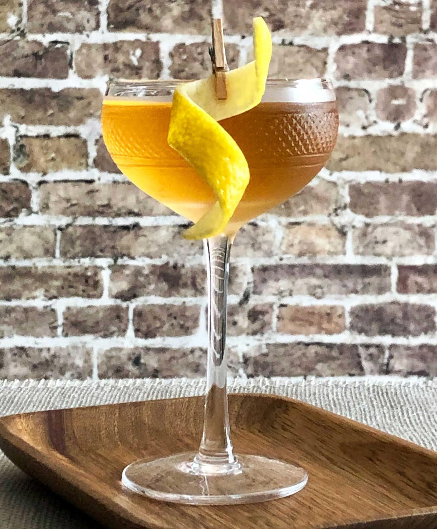 An example of the Empire, the mixed drink (drink), by Savoy Cocktail Book, featuring Hayman’s London Dry Gin, calvados, Rothman & Winter Orchard Apricot Liqueur, and lemon twist; photo by Lee Edwards