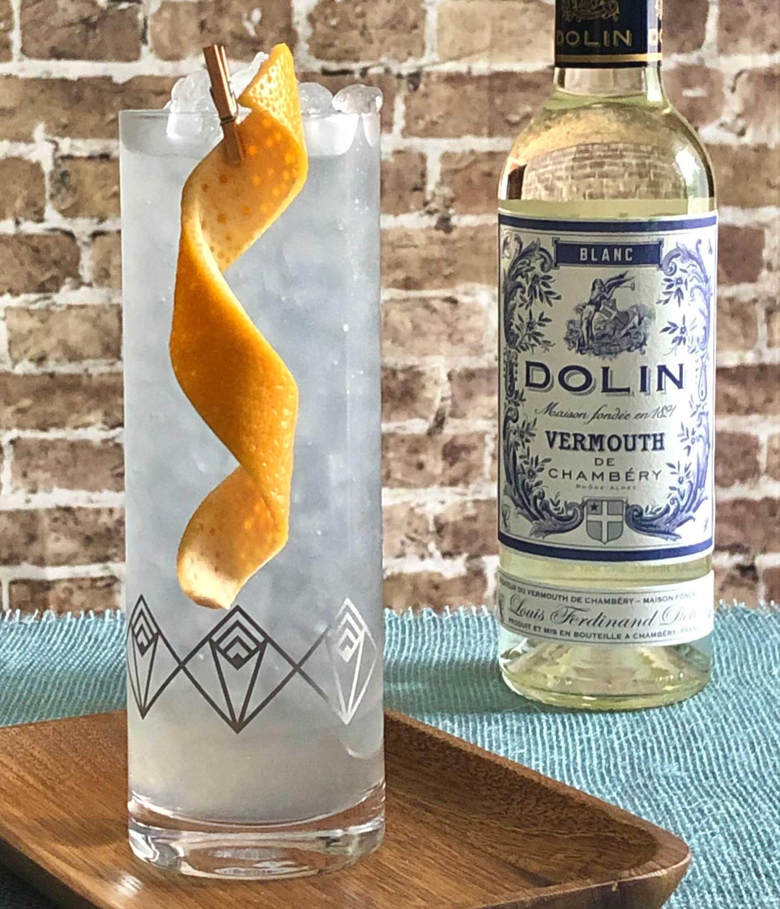 An example of the Canne Collins, the mixed drink (drink) featuring soda water, rhum agricole blanc, Dolin Blanc Vermouth de Chambéry, lemon juice, simple syrup, Rothman & Winter Crème de Violette, and grapefruit twist; photo by Lee Edwards
