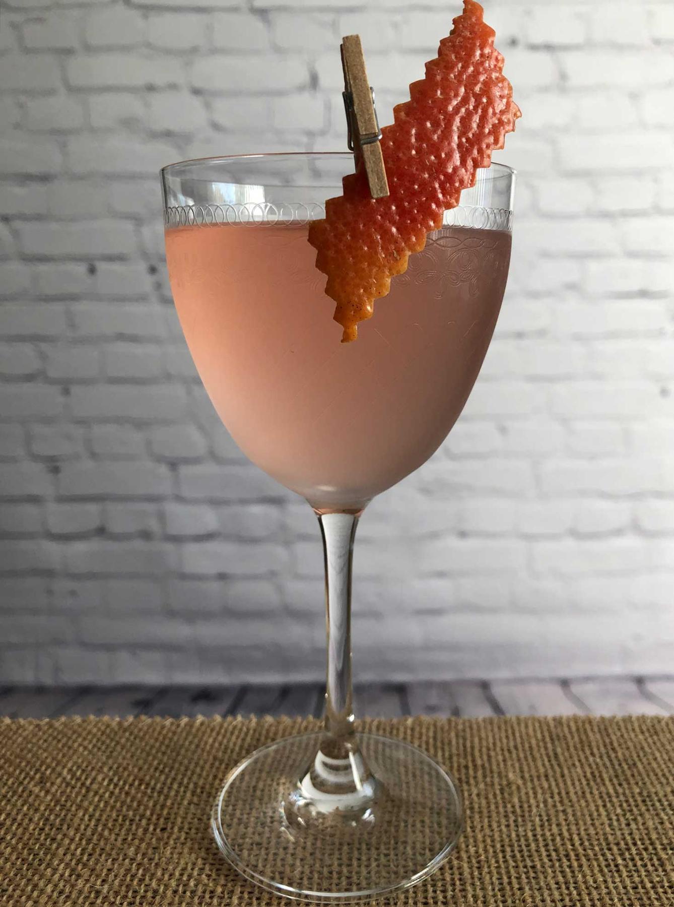 An example of the Alpen Rose, the mixed drink (drink), by Lee Edwards, featuring Dolin Dry Vermouth de Chambéry, Blume Marillen Apricot Eau-de-Vie, Cocchi Americano Rosa, simple syrup, and grapefruit twist; photo by Lee Edwards