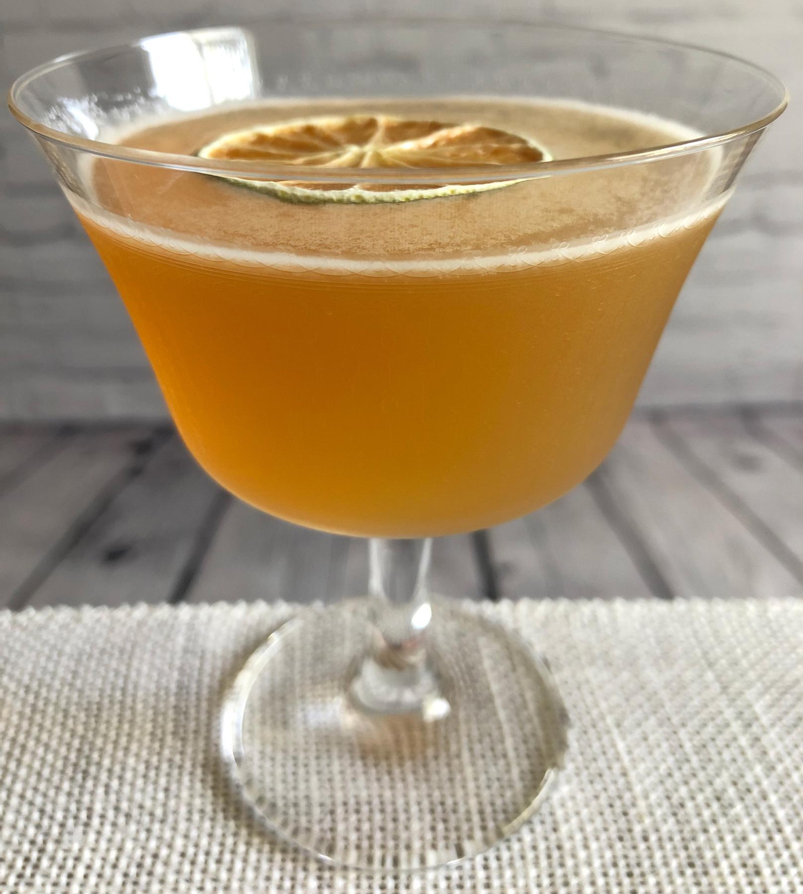 An example of the The Doctor, the mixed drink (drink) featuring KRONAN Swedish Punsch, Smith & Cross Traditional Jamaica Rum, lime juice, and lime wheel; photo by Lee Edwards