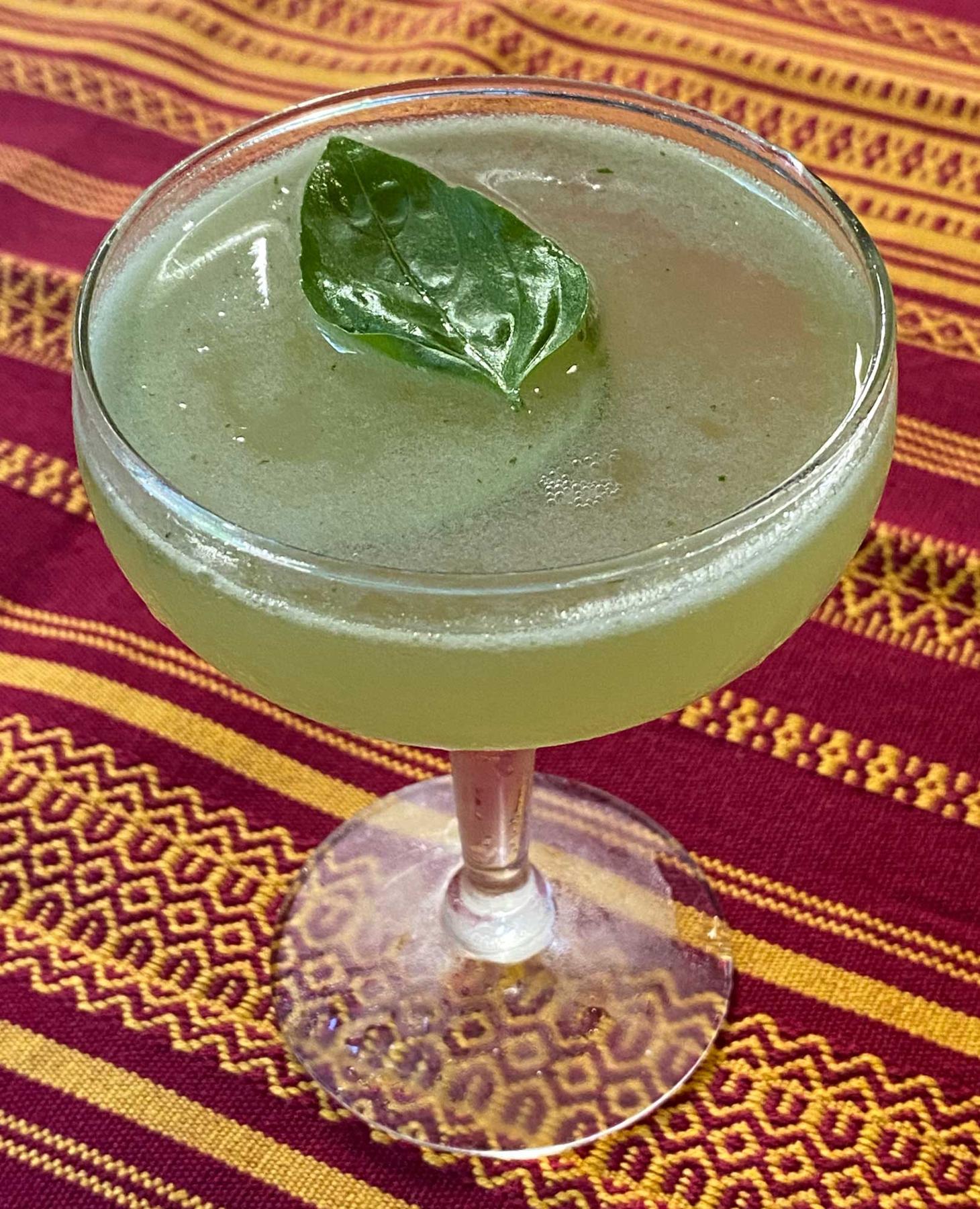 An example of the Basil South Side, the mixed drink (drink) featuring blanco tequila, Salers Gentian Apéritif, lime juice, basil leaves, lemon wheel, and basil leaf; photo by Martin Doudoroff