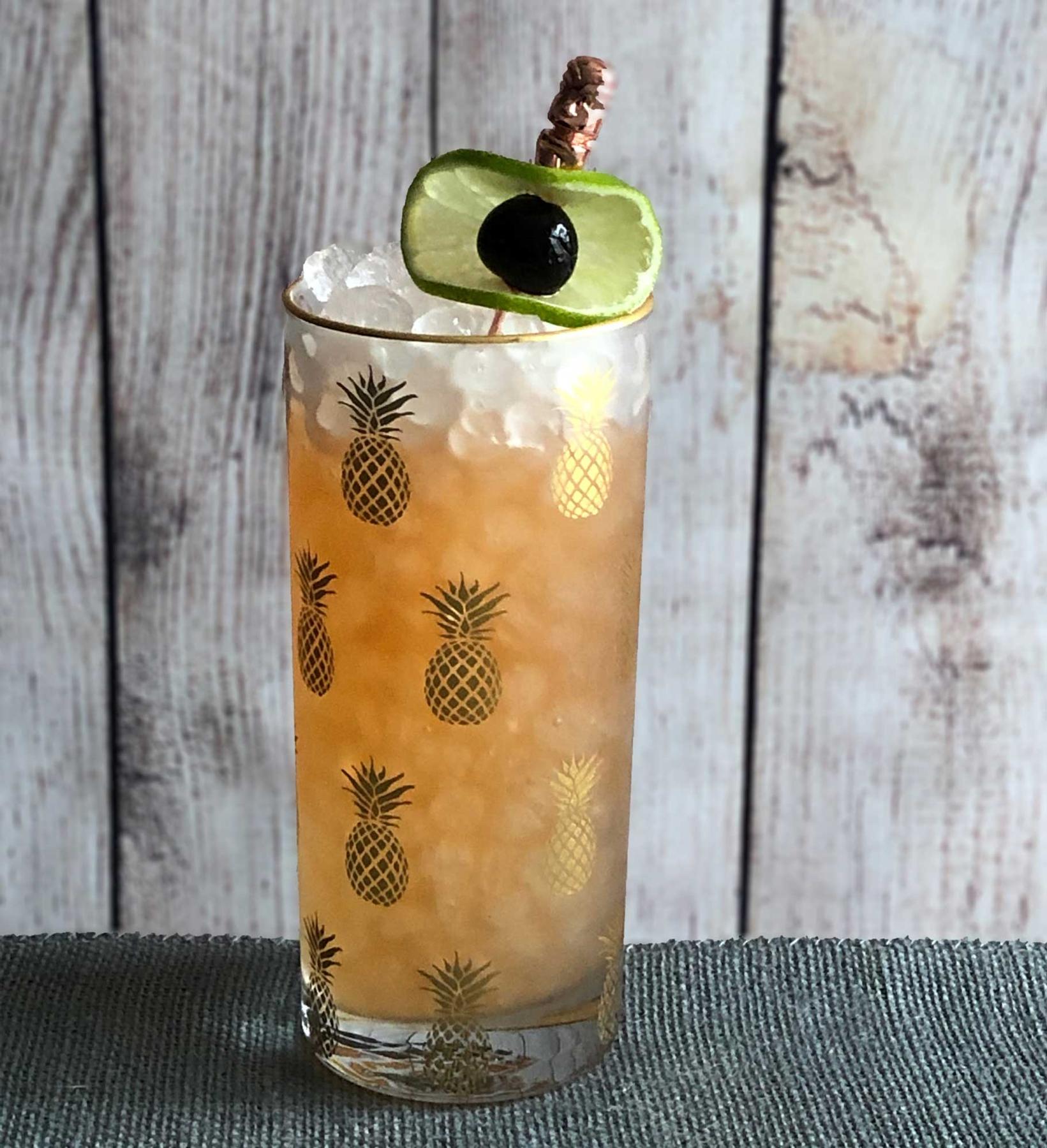 An example of the Rooibos Tea Punch, the mixed drink (drink), by based on a drink by Lauren Mote, Vancouver, BC, featuring ginger beer, The Scarlet Ibis Trinidad Rum, lime juice, John D. Taylor’s Velvet Falernum, rooibus syrup, Angostura bitters, maraschino cherry, and lime wheel; photo by Lee Edwards