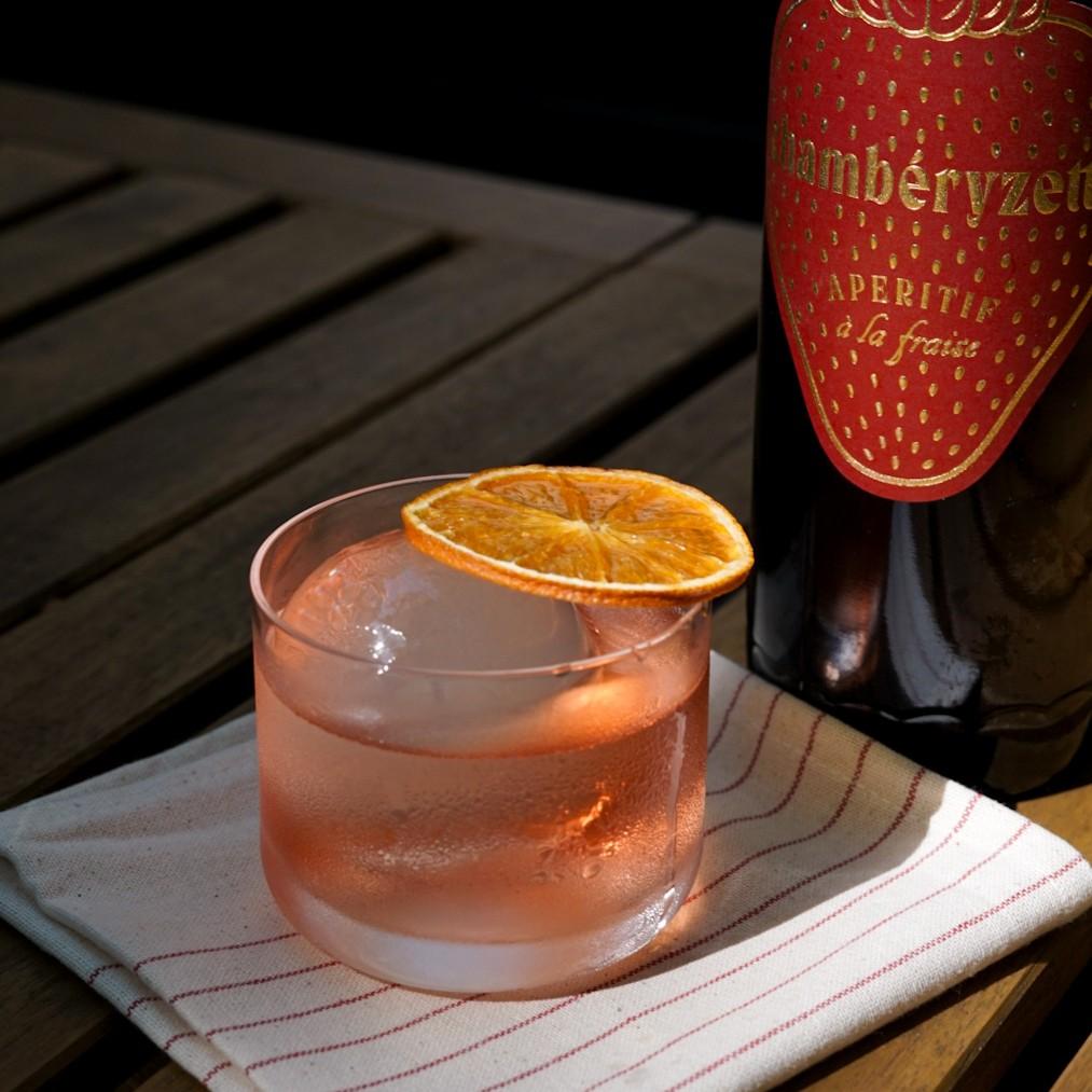 An example of the Wild Strawberry Negroni, the mixed drink (drink) featuring Hayman’s London Dry Gin, Aperitivo Mazzura, Chamberyzette, and orange twist; photo by Madison Young