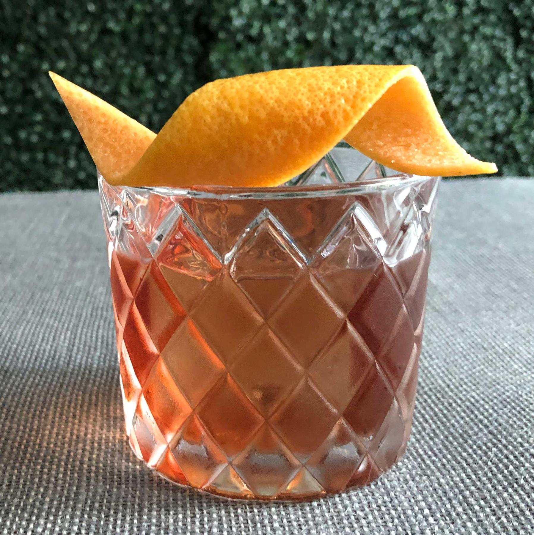 An example of the Count of Mount Kisco, the mixed drink (drink), by Scott Krahn, New York City, featuring Averell Damson Plum Gin Liqueur, Dolin Dry Vermouth de Chambéry, Salers Gentian Apéritif, and grapefruit twist; photo by Lee Edwards