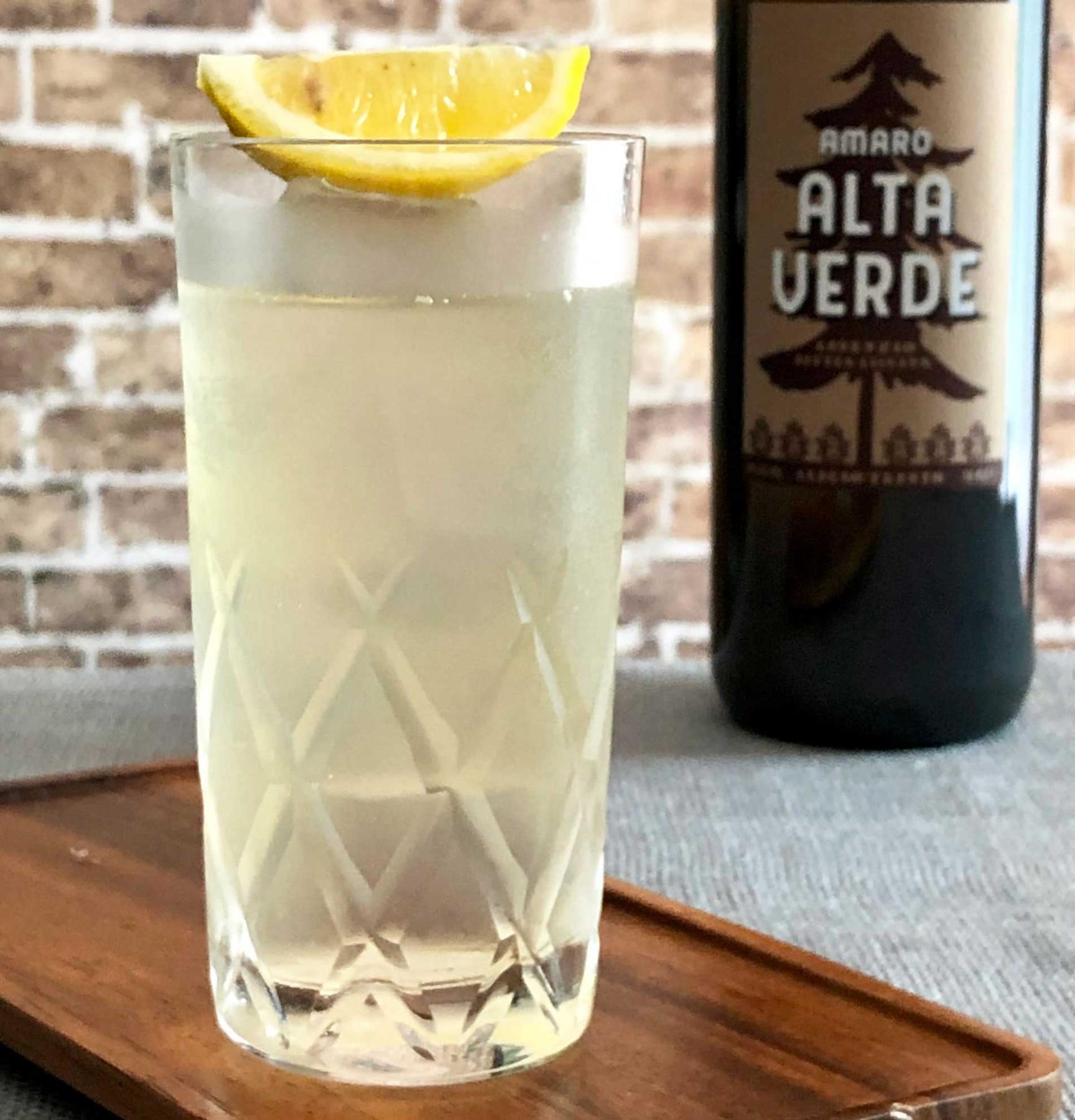 An example of the Verde & Tonic, the mixed drink (drink) featuring tonic water, Amaro Alta Verde, and lime wedge; photo by Lee Edwards