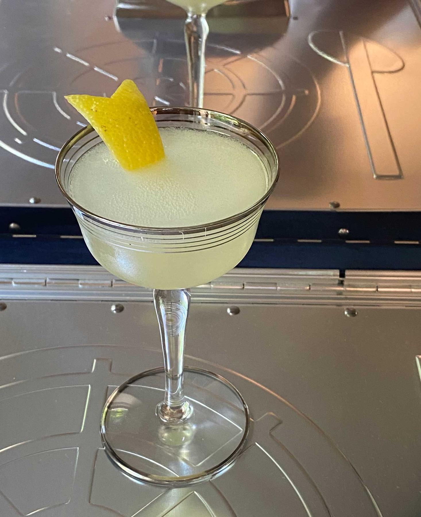 An example of the Twentieth Century, the mixed drink (drink) featuring Hayman’s London Dry Gin, Cocchi Americano Bianco, lemon juice, crème de cacao (white), and lemon twist; photo by Martin Doudoroff