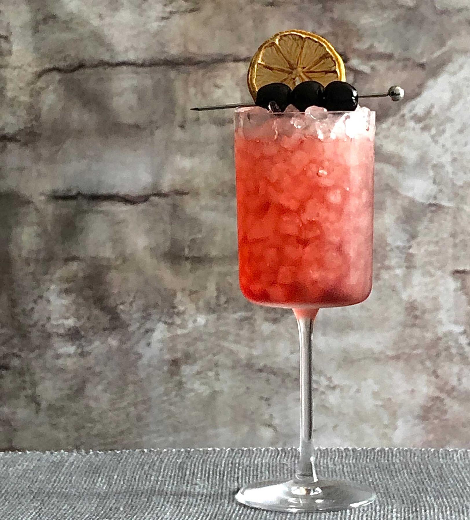 An example of the Cocconato Jubilee, the mixed drink (drink) featuring Cocchi Americano Rosa, soda water, cherry syrup, lemon twist, and maraschino cherry; photo by Lee Edwards