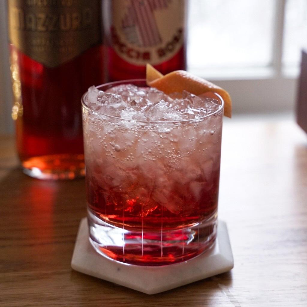 An example of the Sbagliato Rosa, the mixed drink (drink), Adapted from Tom Macy, Brooklyn, NY, featuring sparkling wine, Aperitivo Mazzura, Cocchi Americano Rosa, orange twist, and grapefruit twist; photo by Madison Young