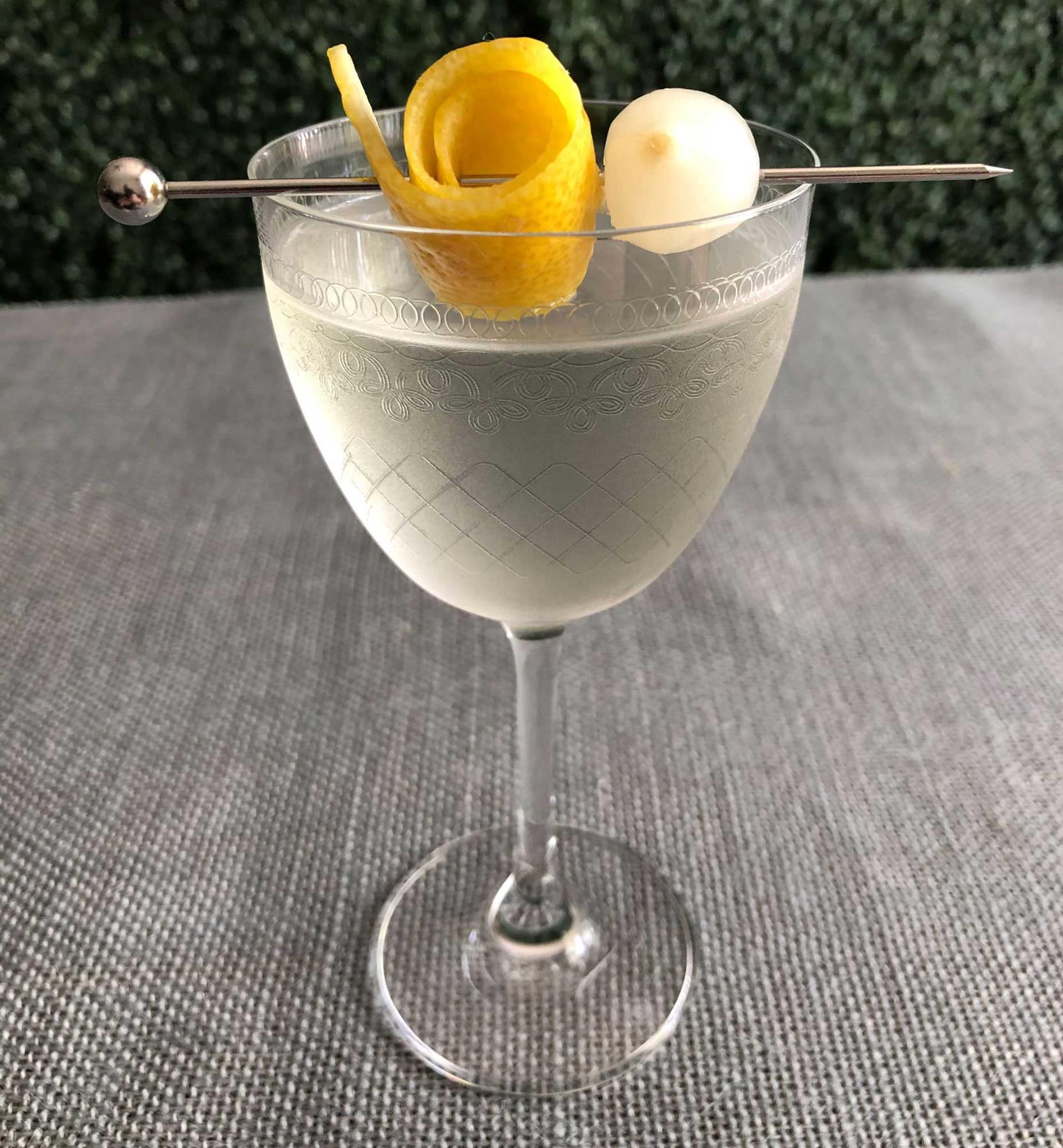 An example of the Roslyn Cocktail, the mixed drink (drink) featuring Hayman’s London Dry Gin, Comoz Blanc Vermouth de Chambèry, Pernod, rose water, lemon twist, and cocktail onion; photo by Lee Edwards