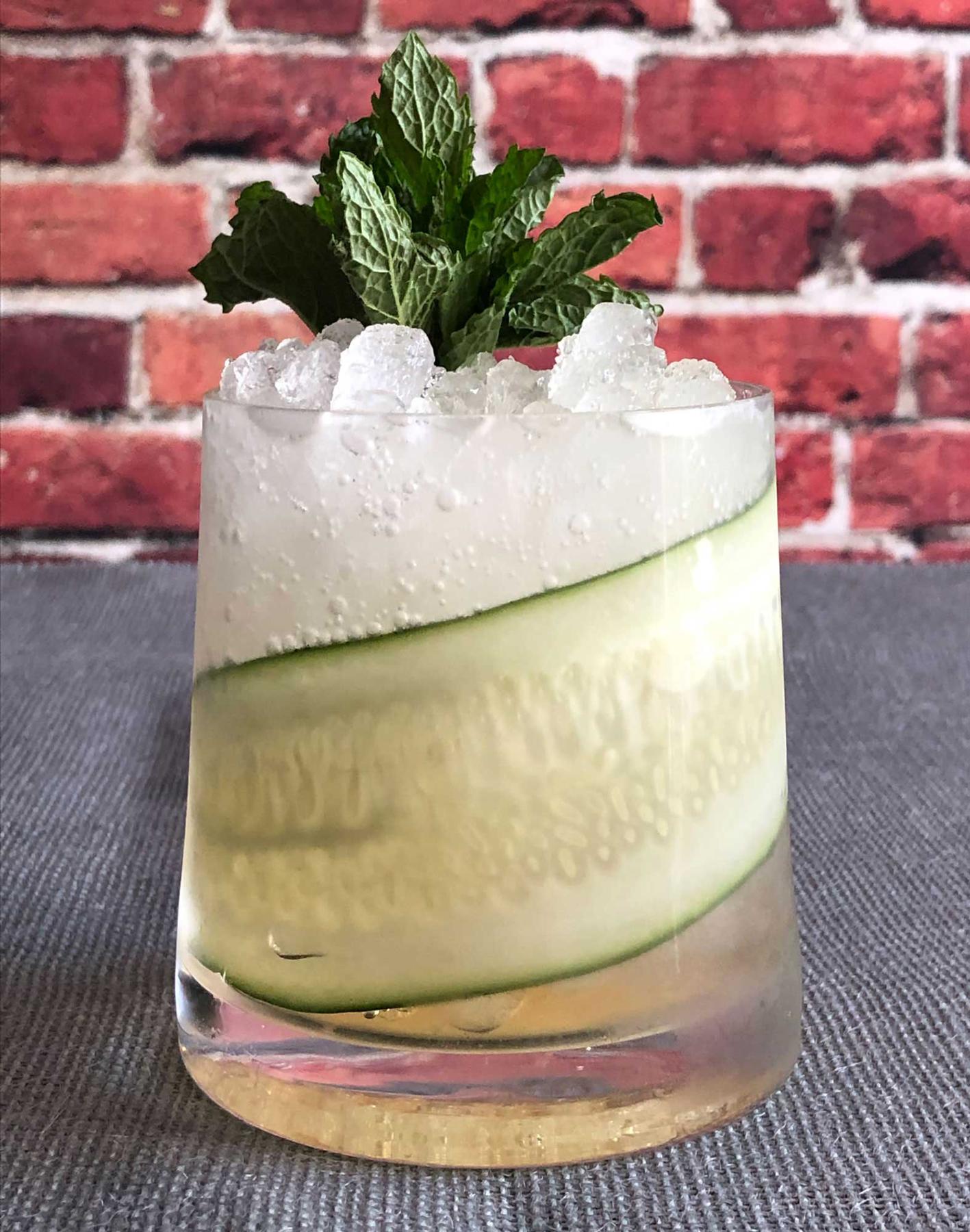 An example of the Capri Classic, the mixed drink (drink), by Macchialina, Miami Beach, Florida, featuring Cocchi Americano Bianco, soda water, sprig of mint, and cucumber slice; photo by Lee Edwards