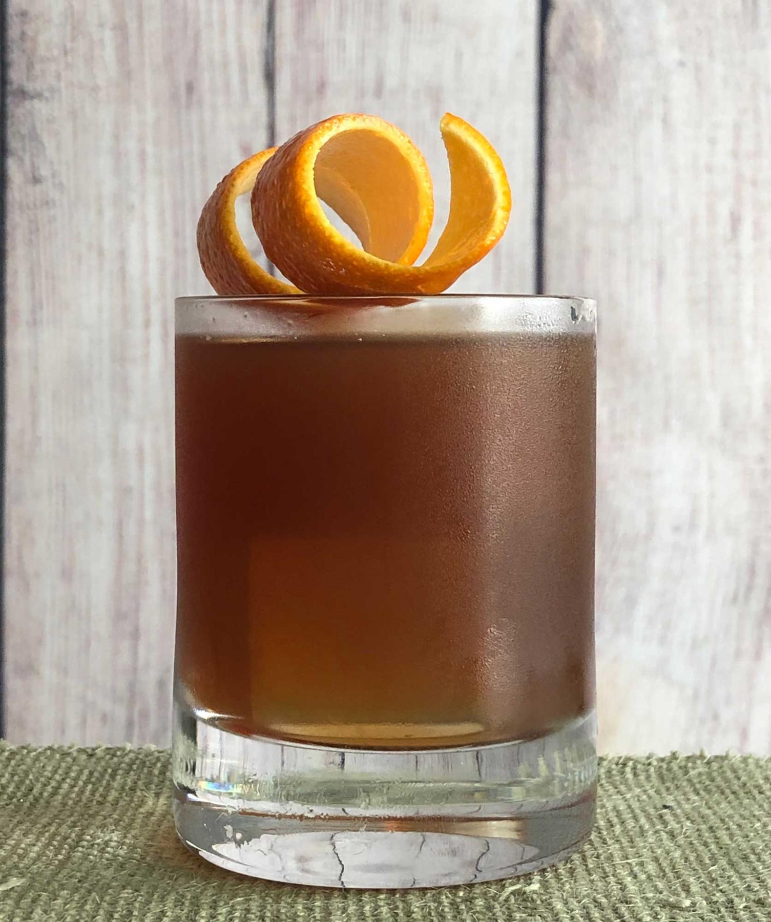 An example of the Sinnerman, the mixed drink (drink), variation of a drink by Mike Fleming, Westbridge, Cambridge, MA, featuring Cocchi Vermouth di Torino ‘Storico’, Salers Gentian Apéritif, St. Elizabeth Allspice Dram, and orange twist; photo by Lee Edwards