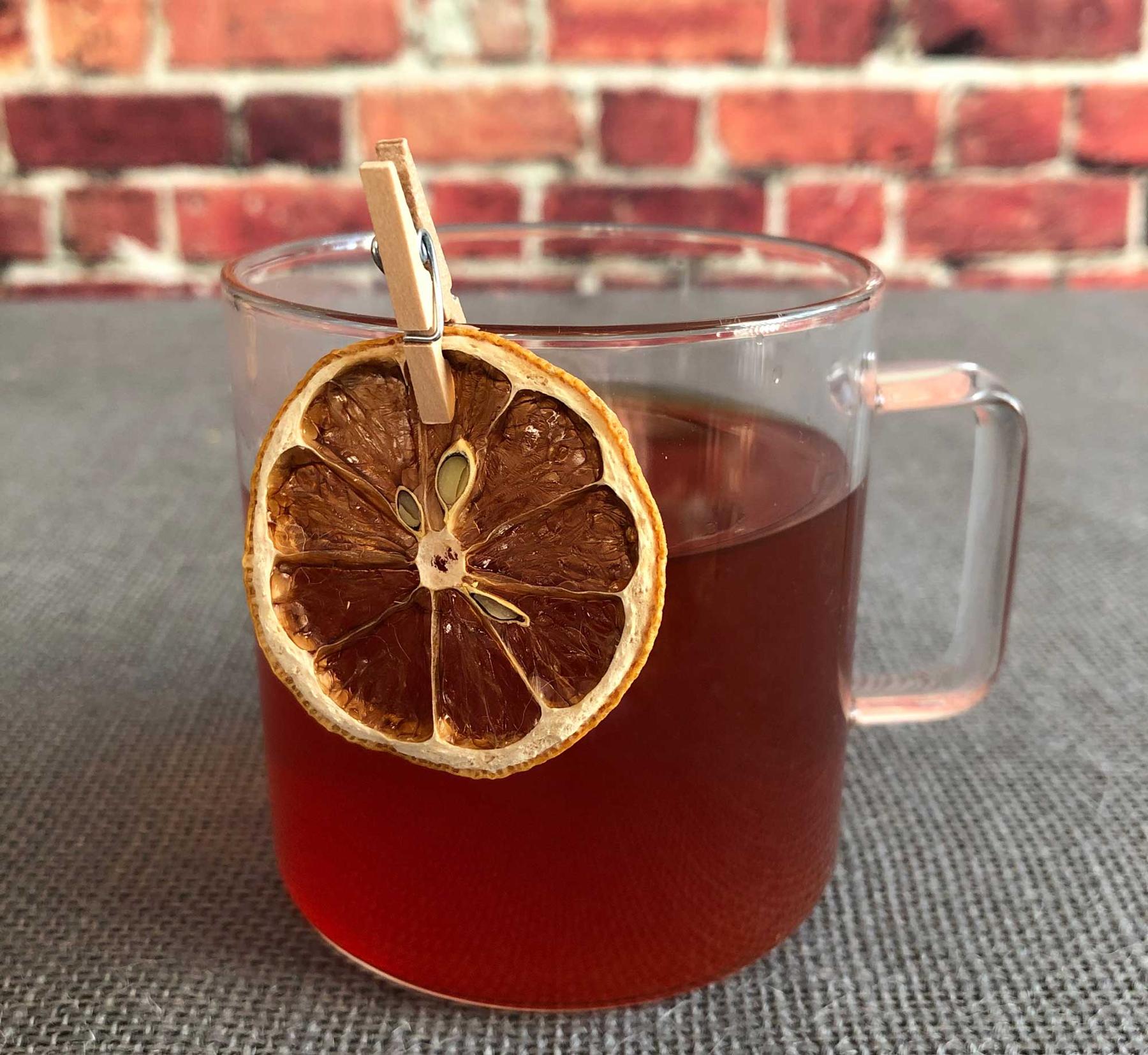 An example of the Bittered Ruby Punch, the mixed drink (drink) featuring black tea, Byrrh Grand Quinquina, Batavia Arrack van Oosten, lemon juice, sugar, and lemon wheel; photo by Lee Edwards